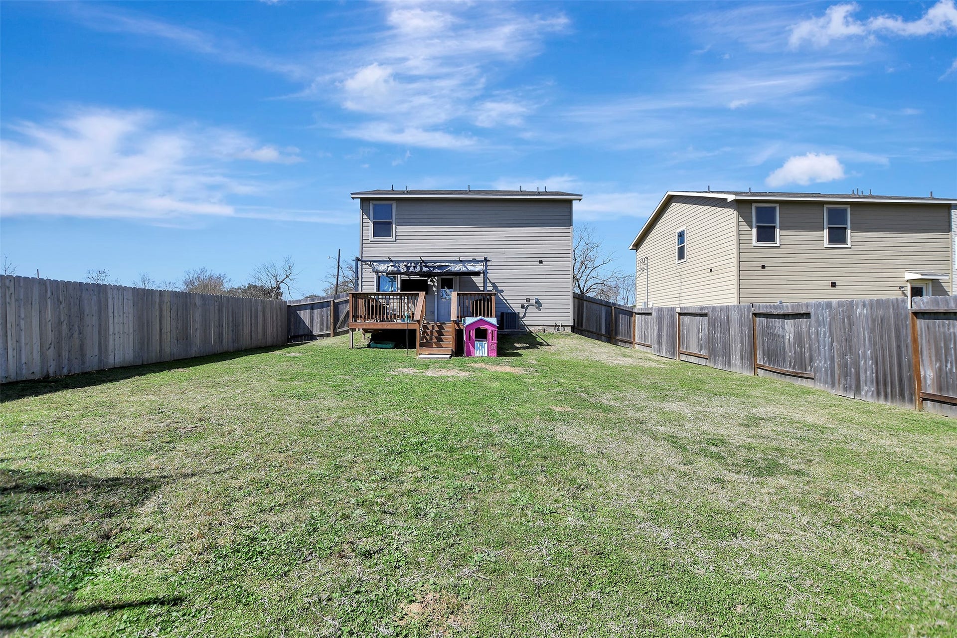 Privacy-fenced backyard situated on the first of two lots, offering secure space for pets, play, or outdoor enjoyment.