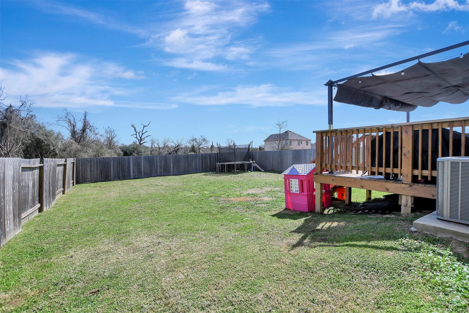Privacy-fenced backyard situated on the first of two lots, offering secure space for pets, play, or outdoor enjoyment.