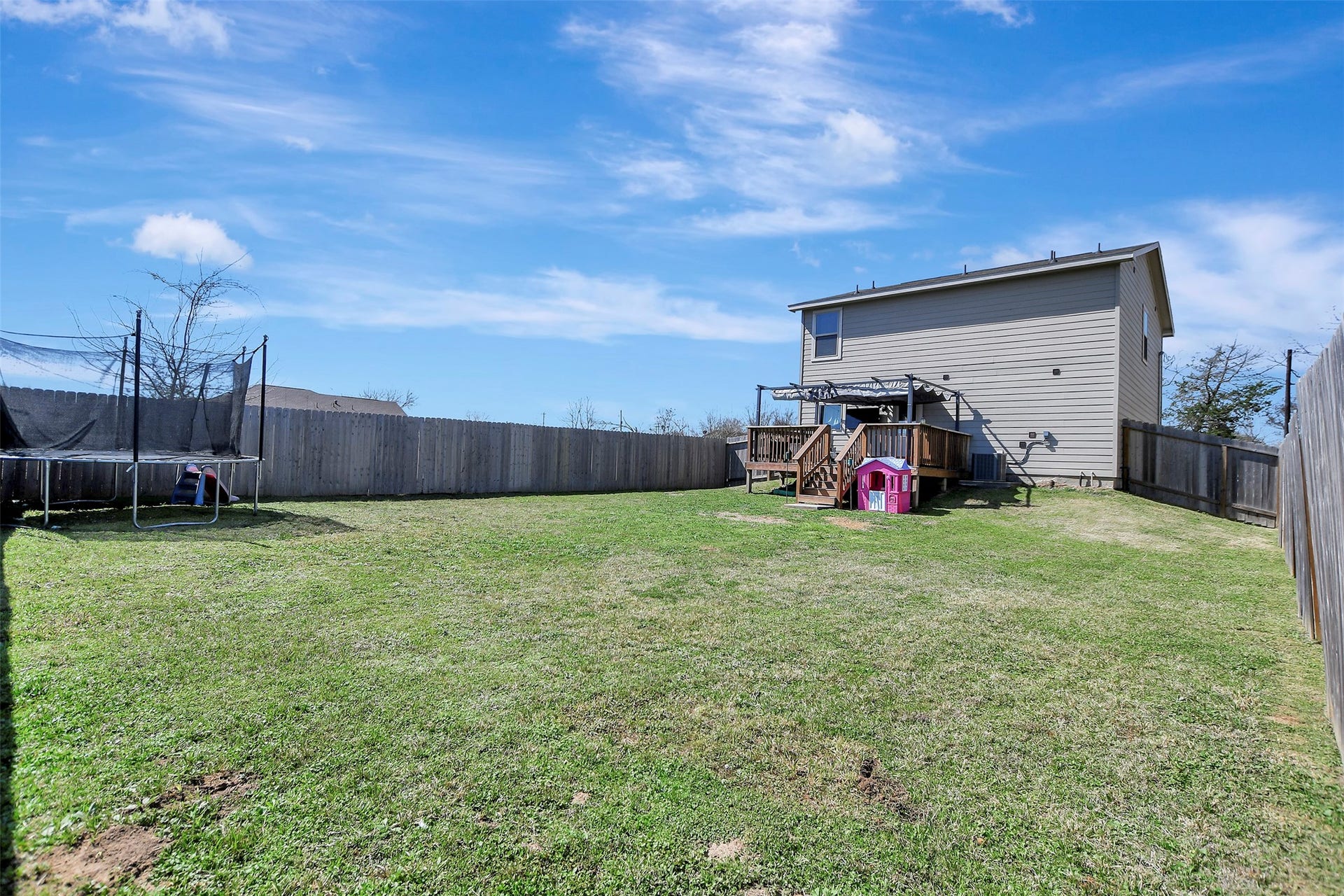 Privacy-fenced backyard situated on the first of two lots, offering secure space for pets, play, or outdoor enjoyment.