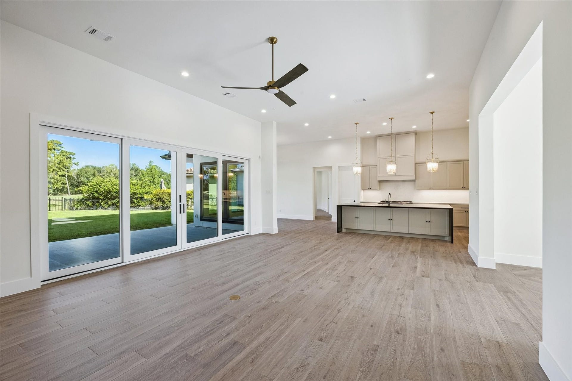 65 Shadow Creek Ridge Drive, Spring, TX 77389 Oversized sliding glass doors stretch across the back wall, inviting natural light and easy indoor-outdoor flow to the covered patio and backyard views.