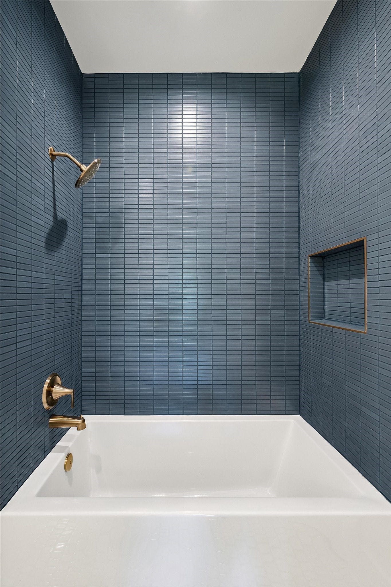 65 Shadow Creek Ridge Drive, Spring, TX 77389 Striking floor-to-ceiling tile surrounds this sleek tub-shower, featuring a built-in niche and luxe fixtures.