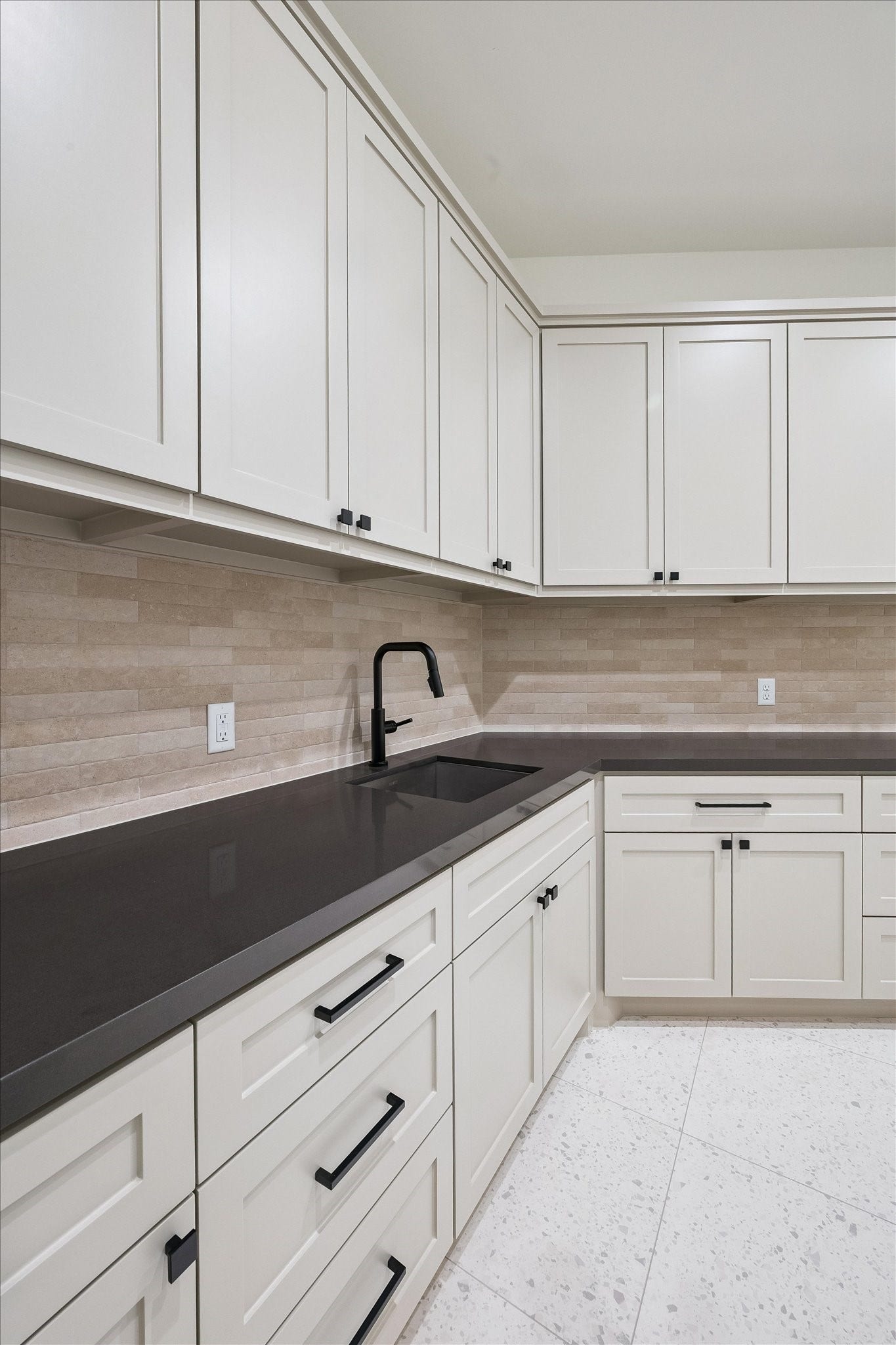 65 Shadow Creek Ridge Drive, Spring, TX 77389 Crisp cream toned shaker cabinetry, sleek dark countertops, and a modern matte-black faucet elevate this kitchen. cabinetry, stone-look counters, and a sleek tile backsplash.