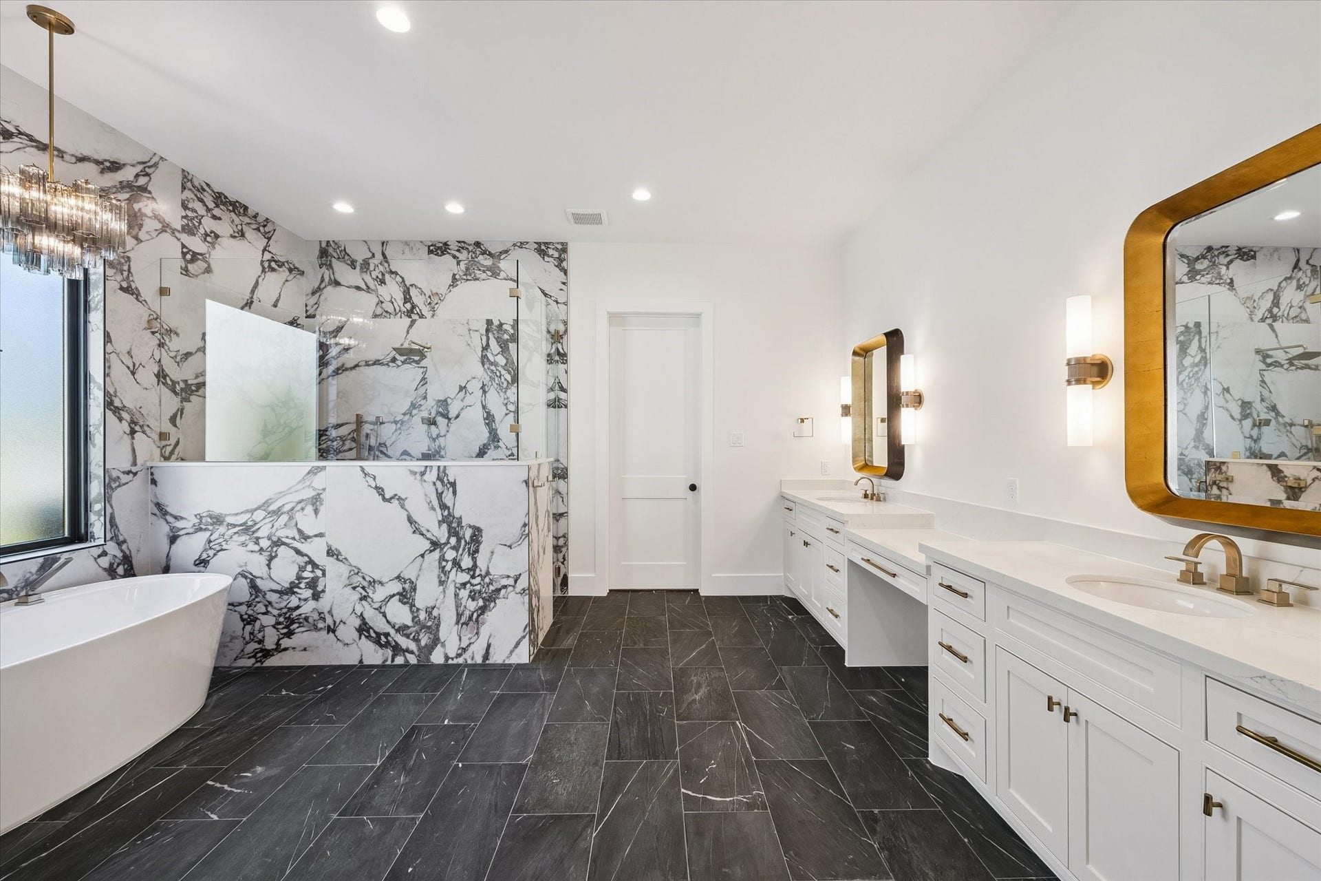 65 Shadow Creek Ridge Drive, Spring, TX 77389 Spa-inspired primary bath showcases dramatic marble-look tile, glass shower, freestanding tub, and dual vanity.