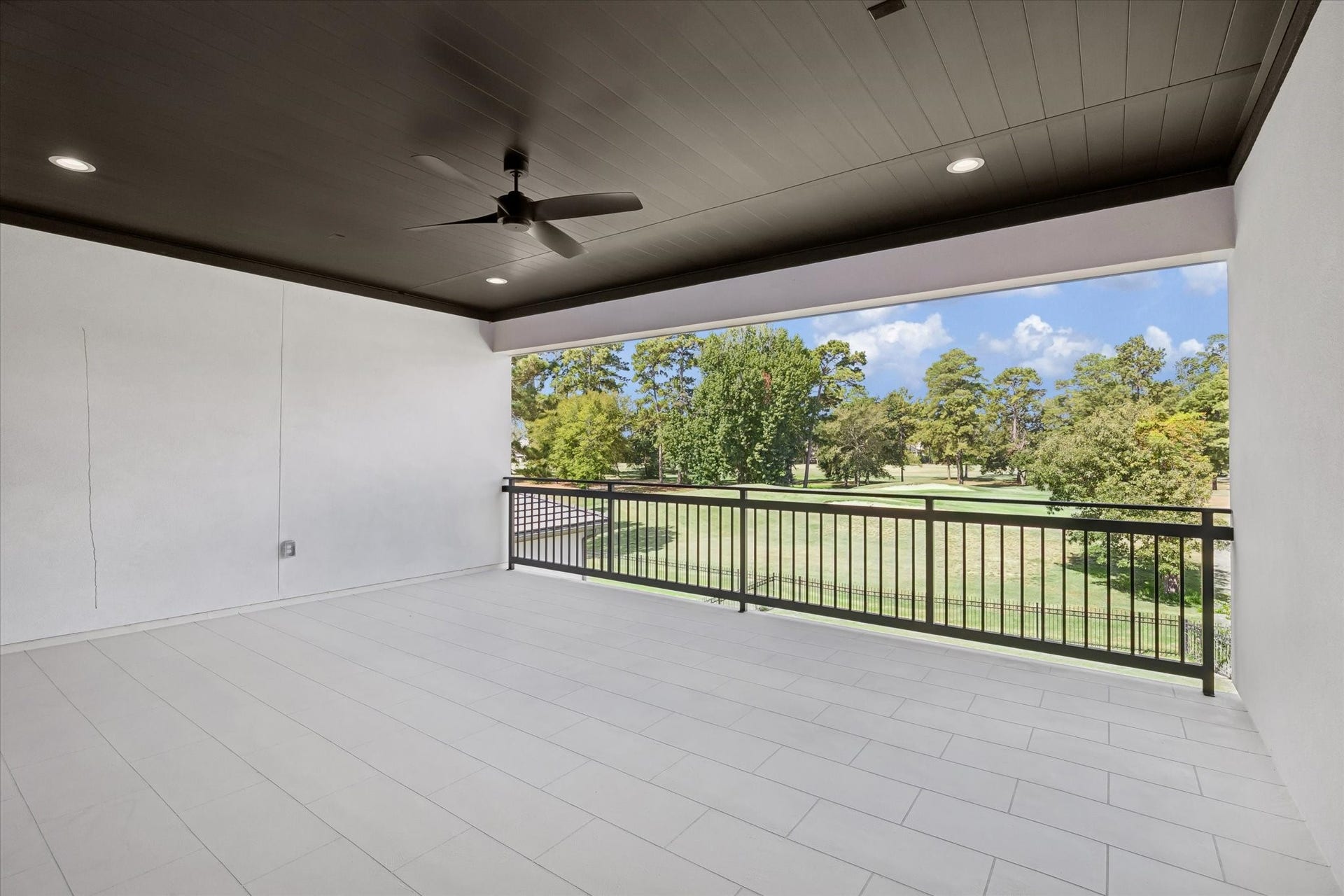 65 Shadow Creek Ridge Drive, Spring, TX 77389 Covered balcony with ceiling fan, recessed lighting, and sleek railing overlooking serene golf course greens.