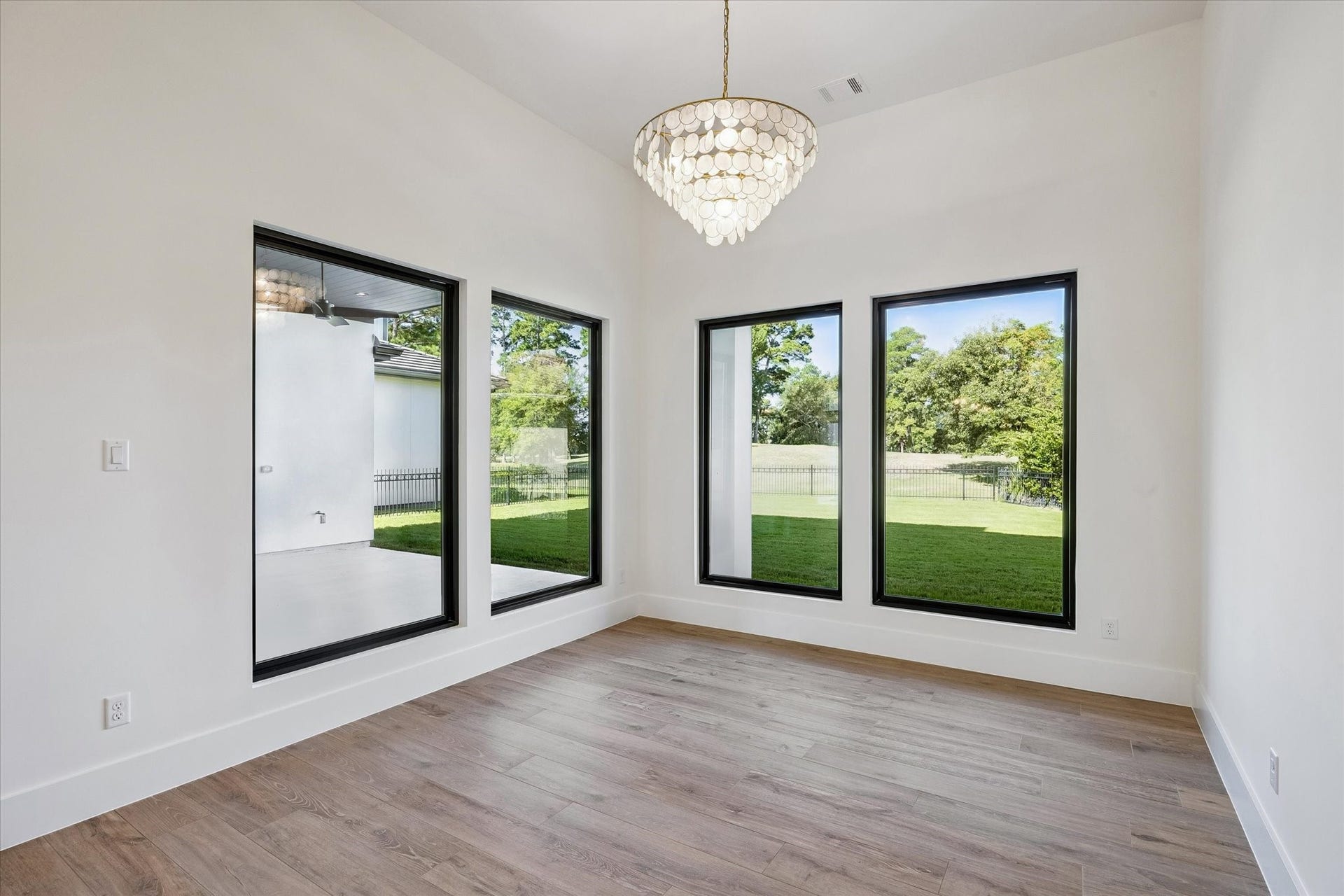 65 Shadow Creek Ridge Drive, Spring, TX 77389 A wall of oversized, black-framed windows steals the show here, bringing in abundant natural light and framing peaceful green views to this dinning space.