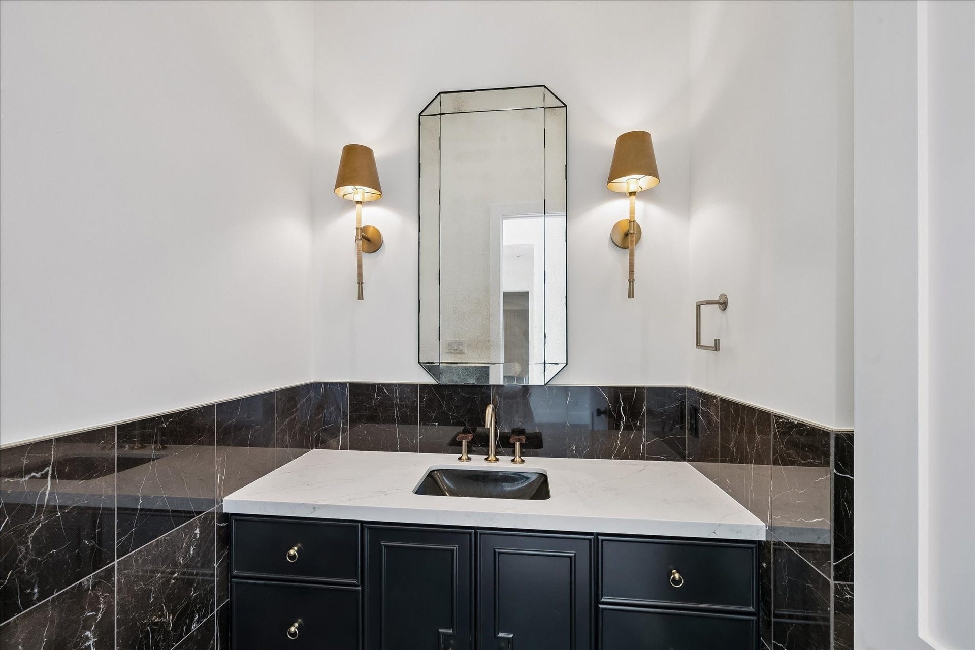 65 Shadow Creek Ridge Drive, Spring, TX 77389 Stylish powder bath with bold stone wainscoting, quartz vanity top, and designer sconces.