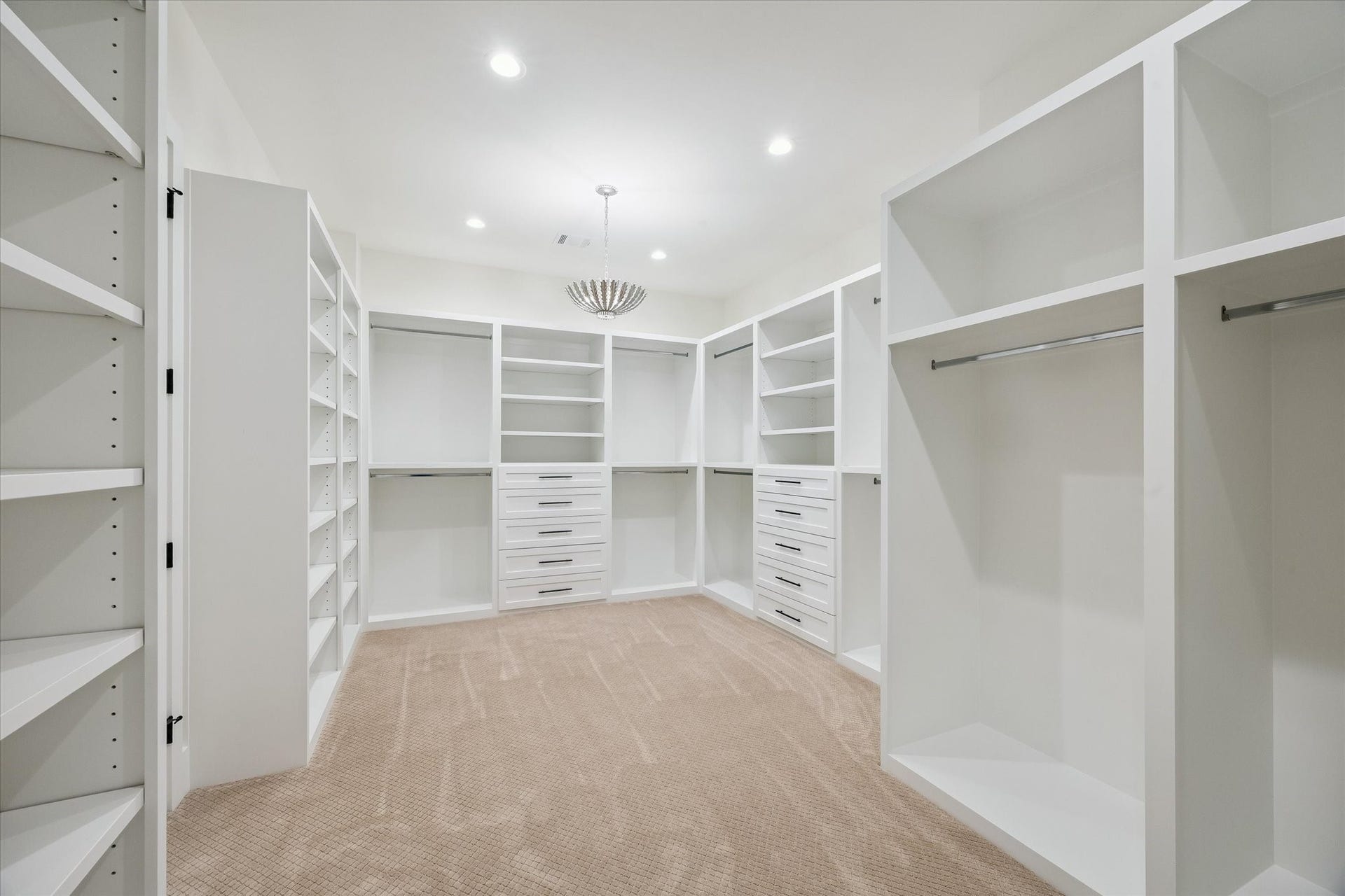 65 Shadow Creek Ridge Drive, Spring, TX 77389 Boutique-style walk-in closet with custom built-ins, drawers, and bright recessed lighting throughout.