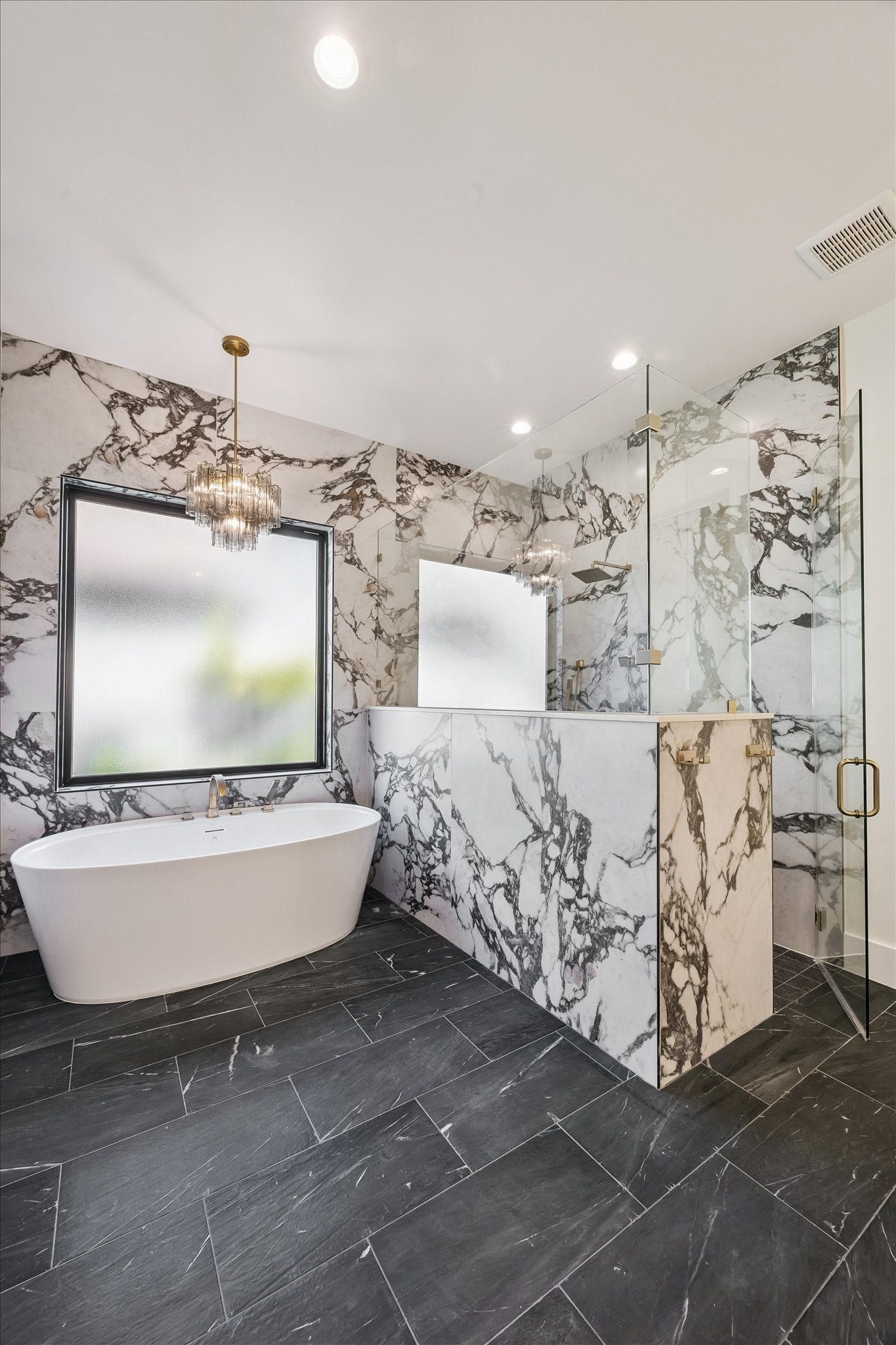 65 Shadow Creek Ridge Drive, Spring, TX 77389 In the primary bathroom, bold marble-style wall surrounds make an instant statement.