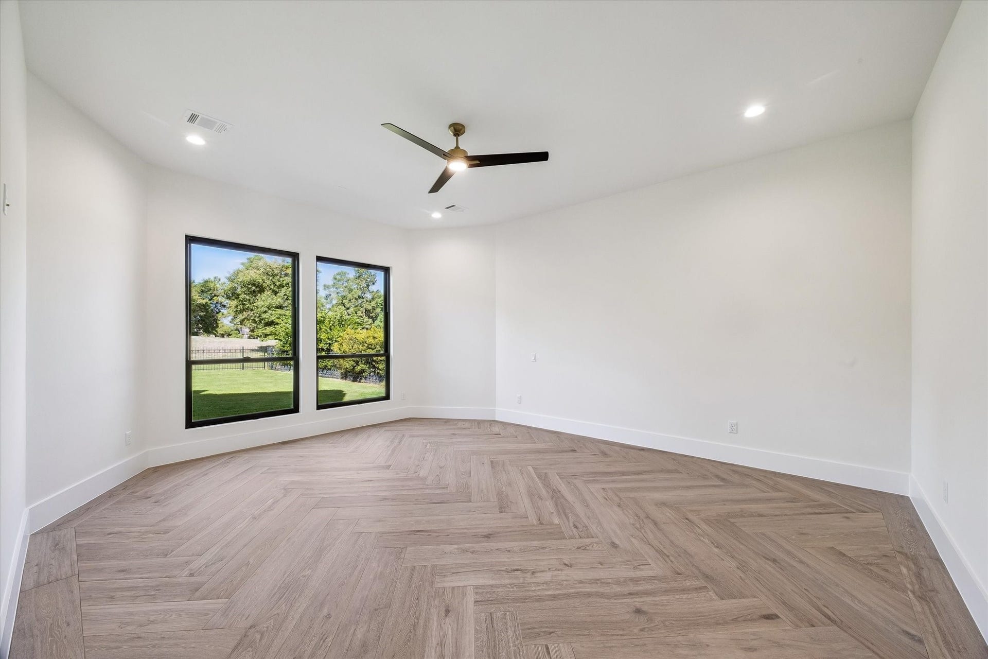 65 Shadow Creek Ridge Drive, Spring, TX 77389 The crisp white walls pair beautifully with the wood-style herringbone tile flooring, and the generous footprint makes it easy to relax in this primary suite.