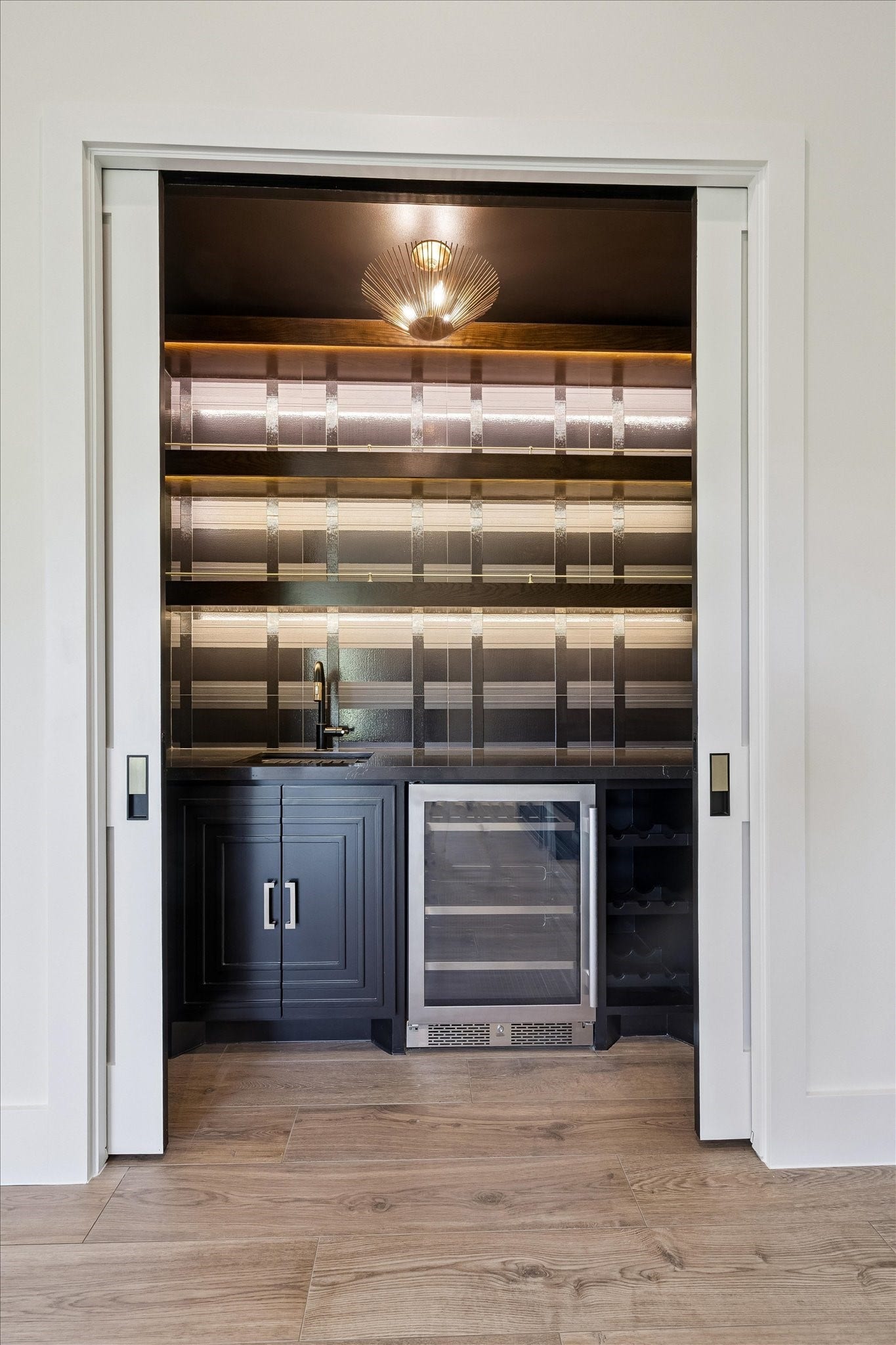 65 Shadow Creek Ridge Drive, Spring, TX 77389 Tucked behind sleek pocket doors, this dedicated bar area brings a boutique feel to everyday living.