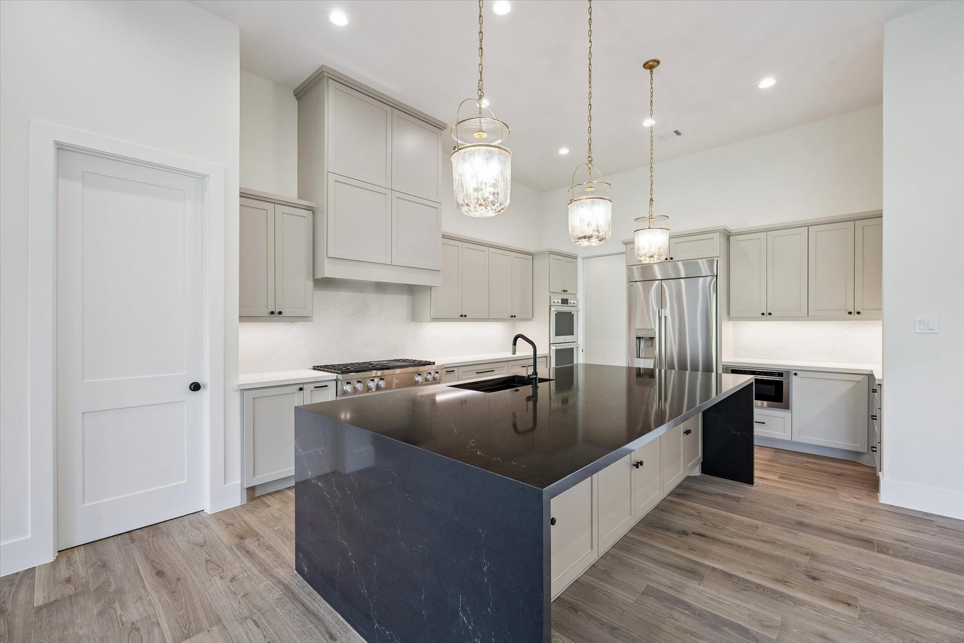 65 Shadow Creek Ridge Drive, Spring, TX 77389 Soft toned shaker cabinetry stretches to the ceiling for a clean, custom look, while under-cabinet lighting and a full-height backsplash keep things bright and polished.