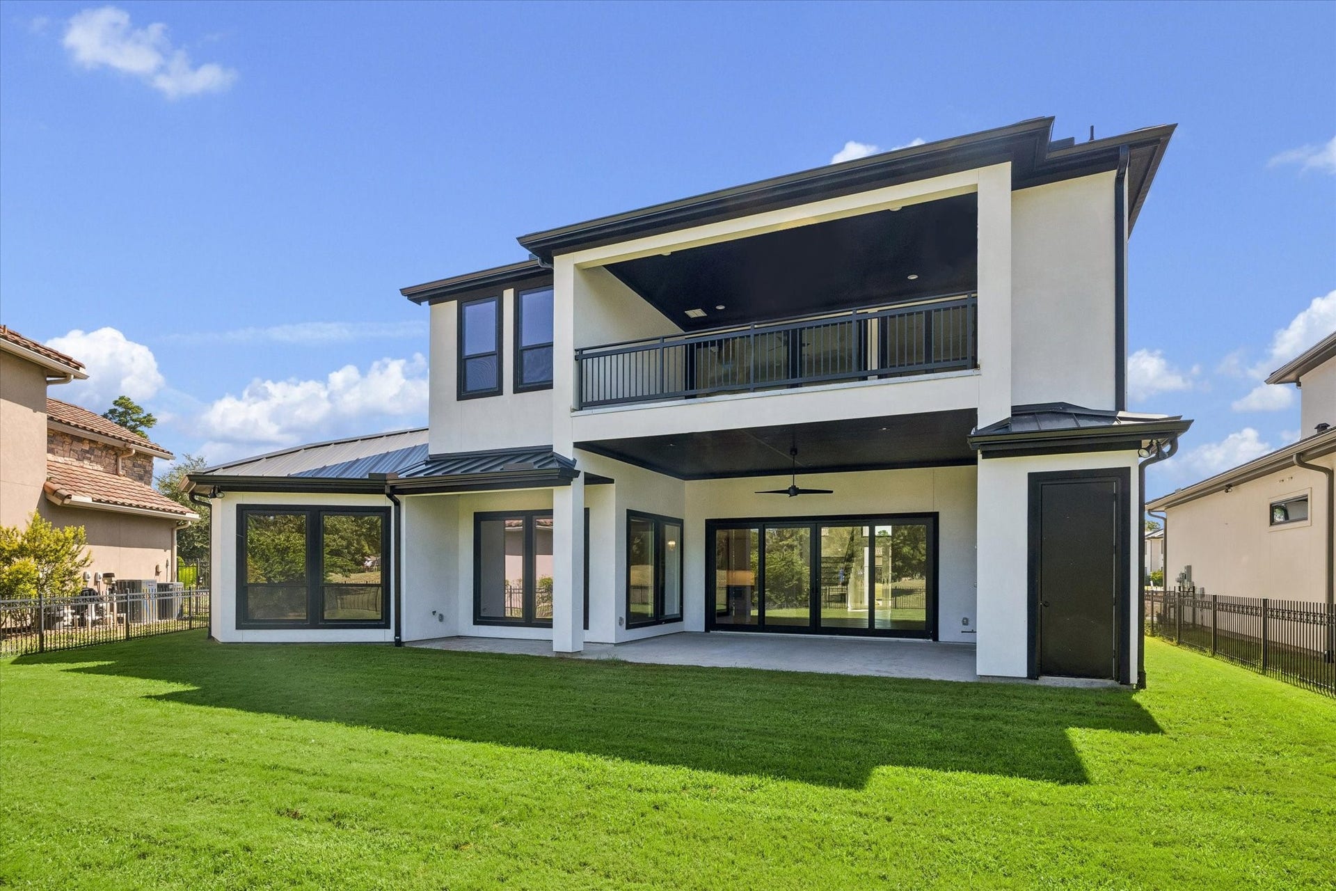 65 Shadow Creek Ridge Drive, Spring, TX 77389 Modern backyard elevation with covered patio, second-story balcony, and expansive sliders to the yard.