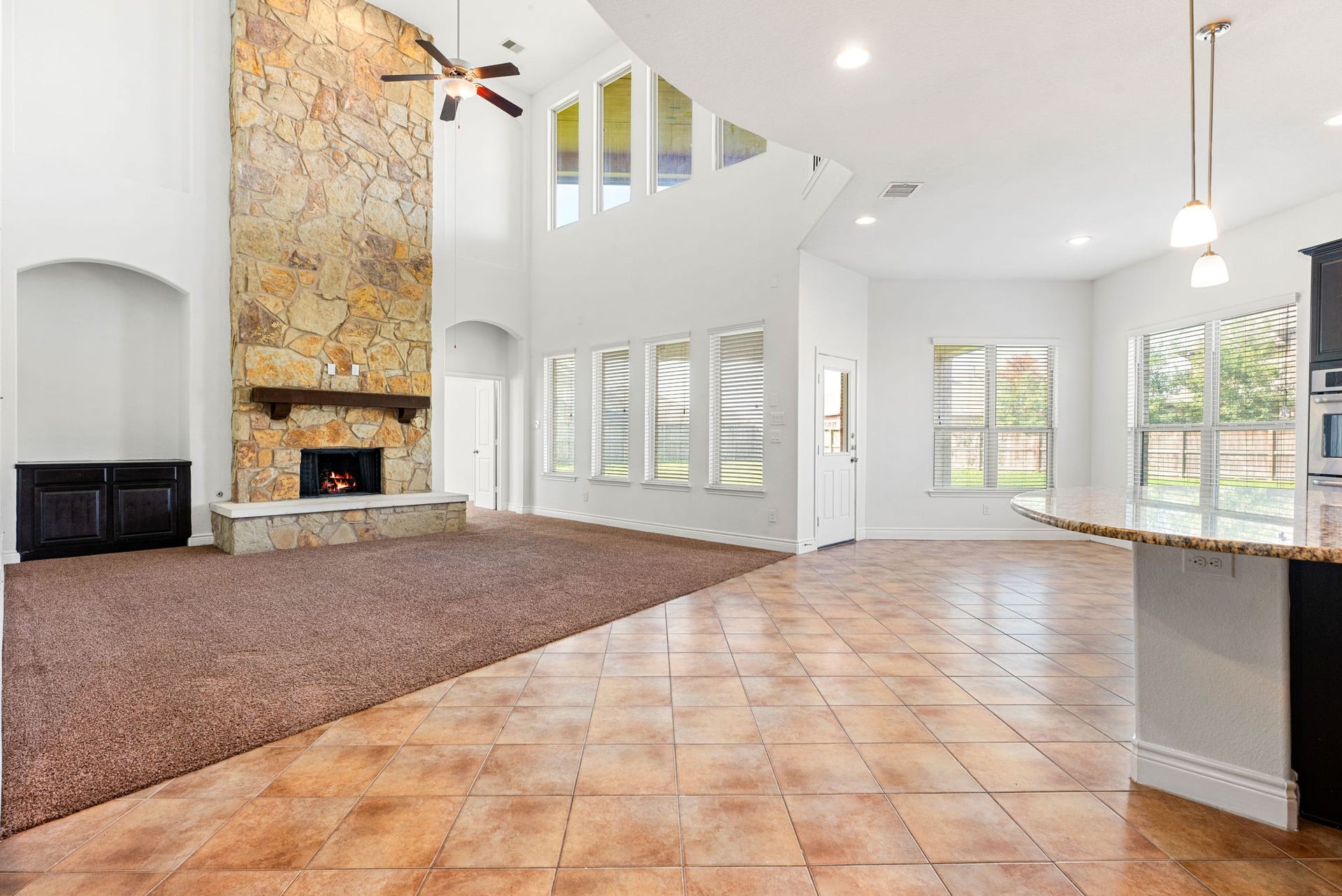 3318 Elizabeth Springs Court, Katy, TX 77494 Two-story stone fireplace with abundant windows opens to kitchen.