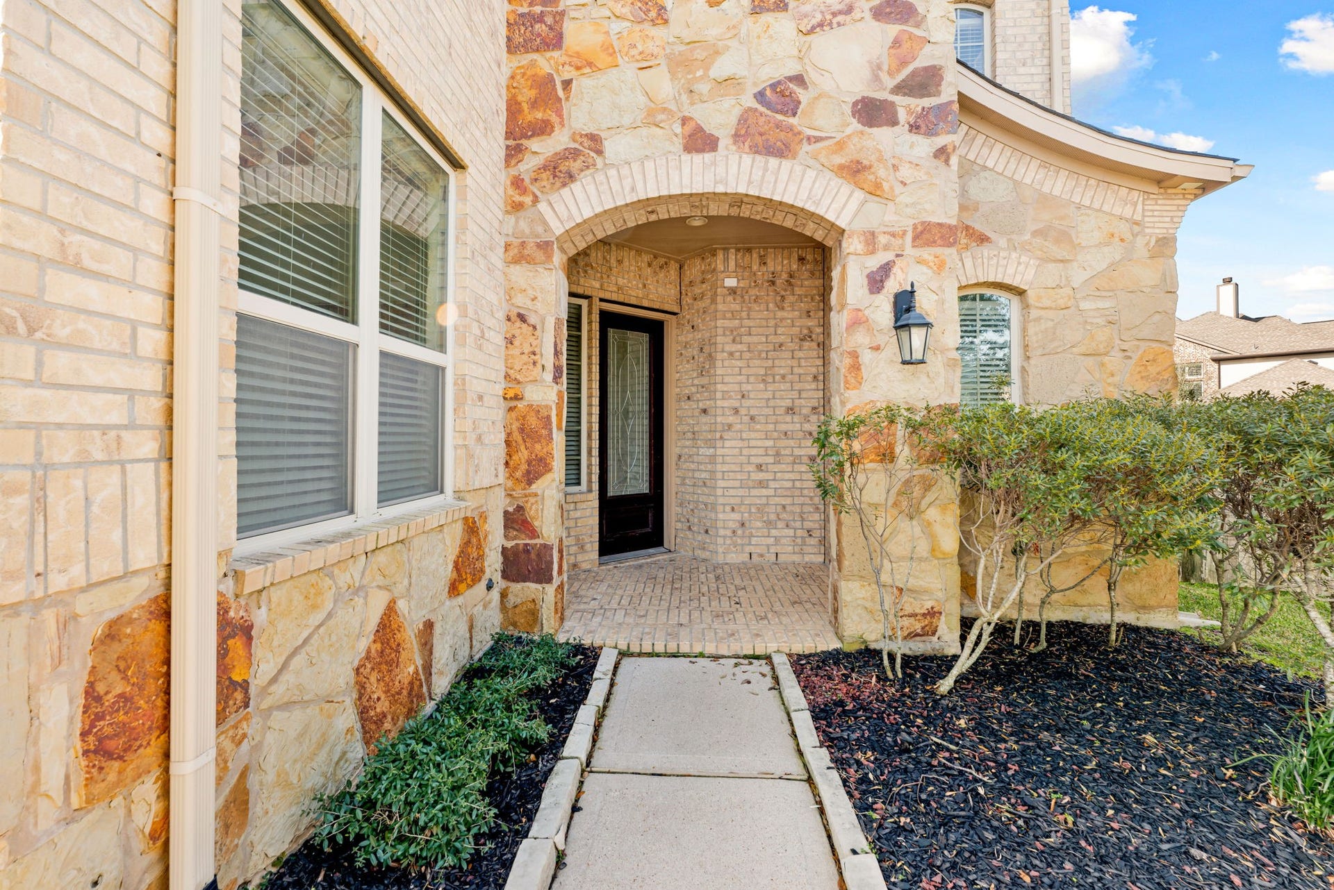 3318 Elizabeth Springs Court, Katy, TX 77494 Elegant stone and brick exterior with covered patio.
