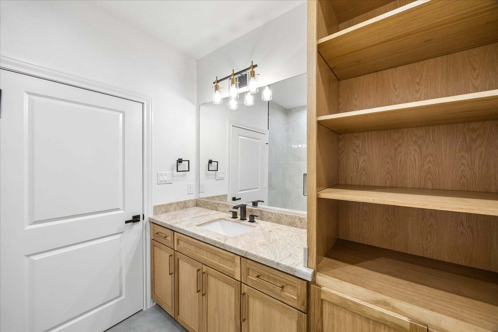 Another upstairs bathroom featuring custom built in shelving, providing stylish storage and added convenience.