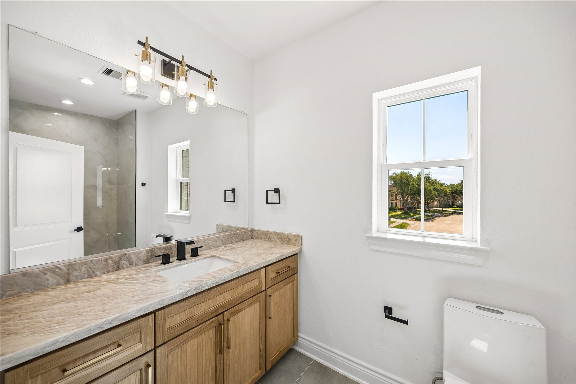 Upstairs ensuite bathroom offers a generous counter space with Taj Mahal countertops that add a touch of luxury.