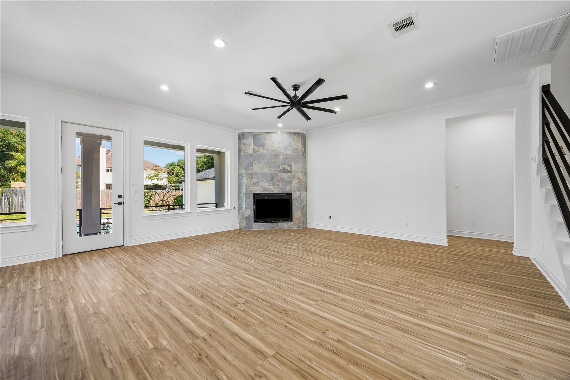 Beautiful floor-to-ceiling tile gas fireplace serves as a stunning focal point in the spacious family room, adding modern elegance and warmth to the living space.