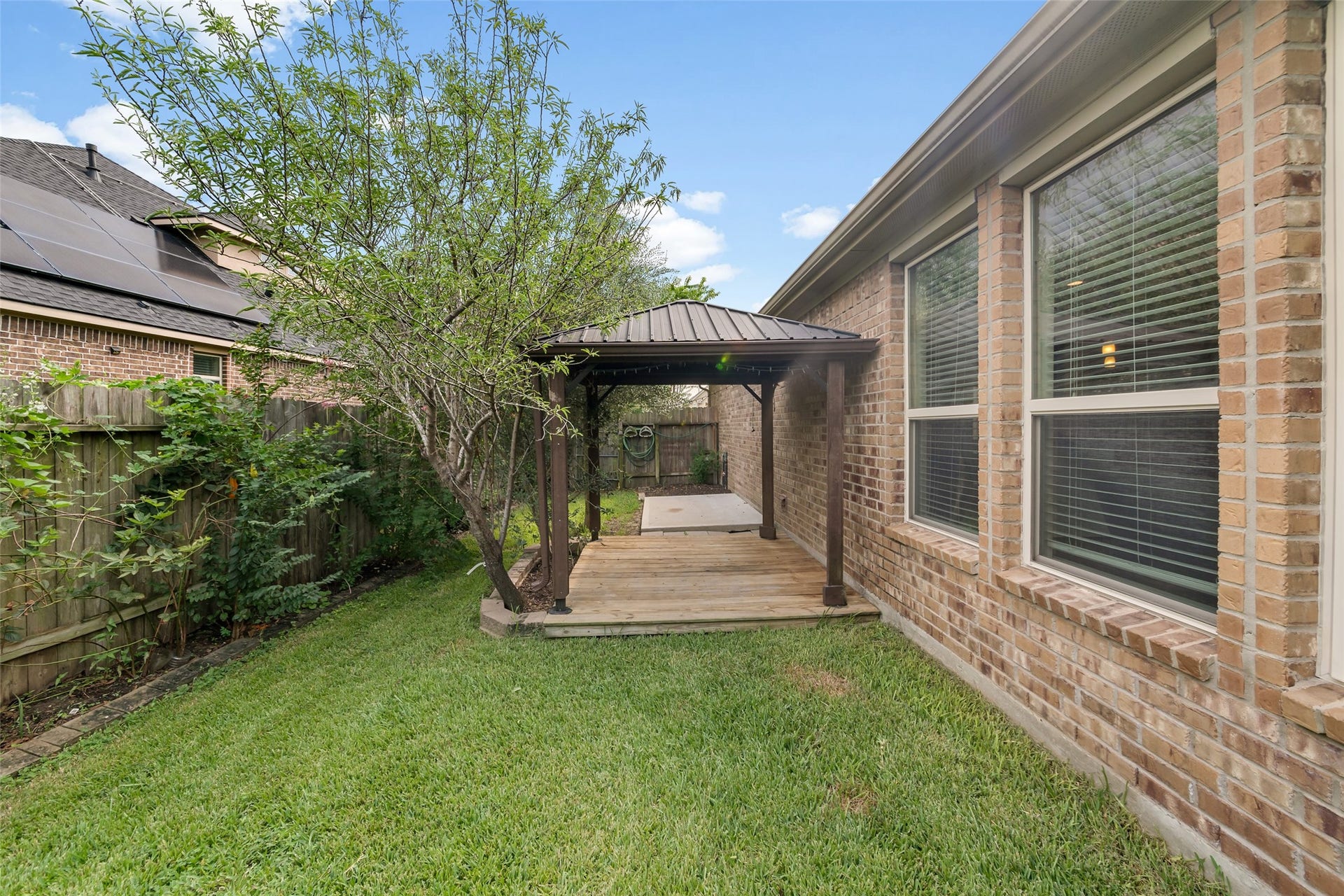 12218 Rampy Green Drive, Tomball, TX 77377 Cozy pergola-covered deck, perfect for outdoor relaxation and entertainment.