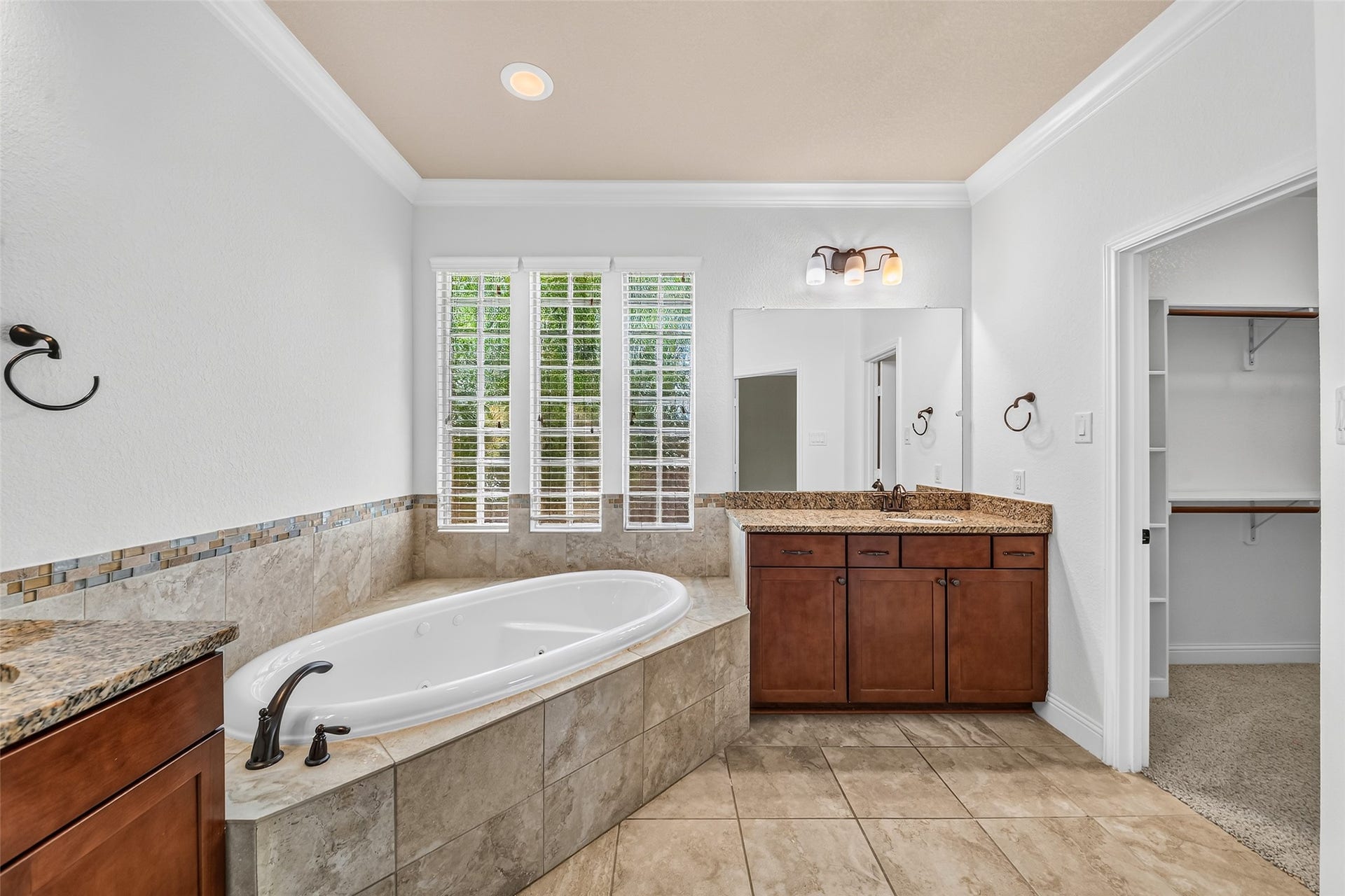 12218 Rampy Green Drive, Tomball, TX 77377 Elegant primary bathroom featuring a luxurious corner tub, dual sinks with granite countertops.
