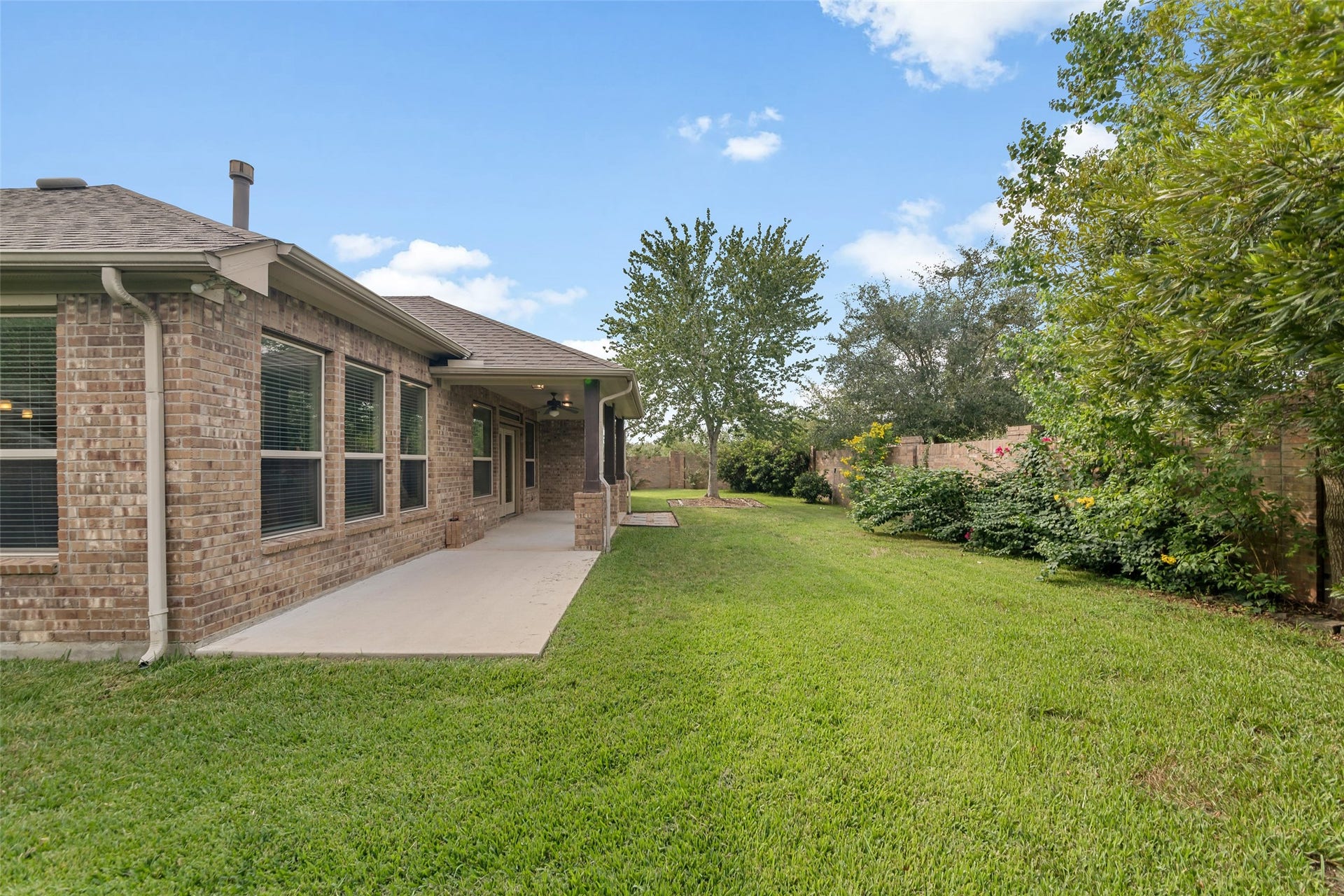 12218 Rampy Green Drive, Tomball, TX 77377 Lush lawn with mature trees providing shade and privacy.