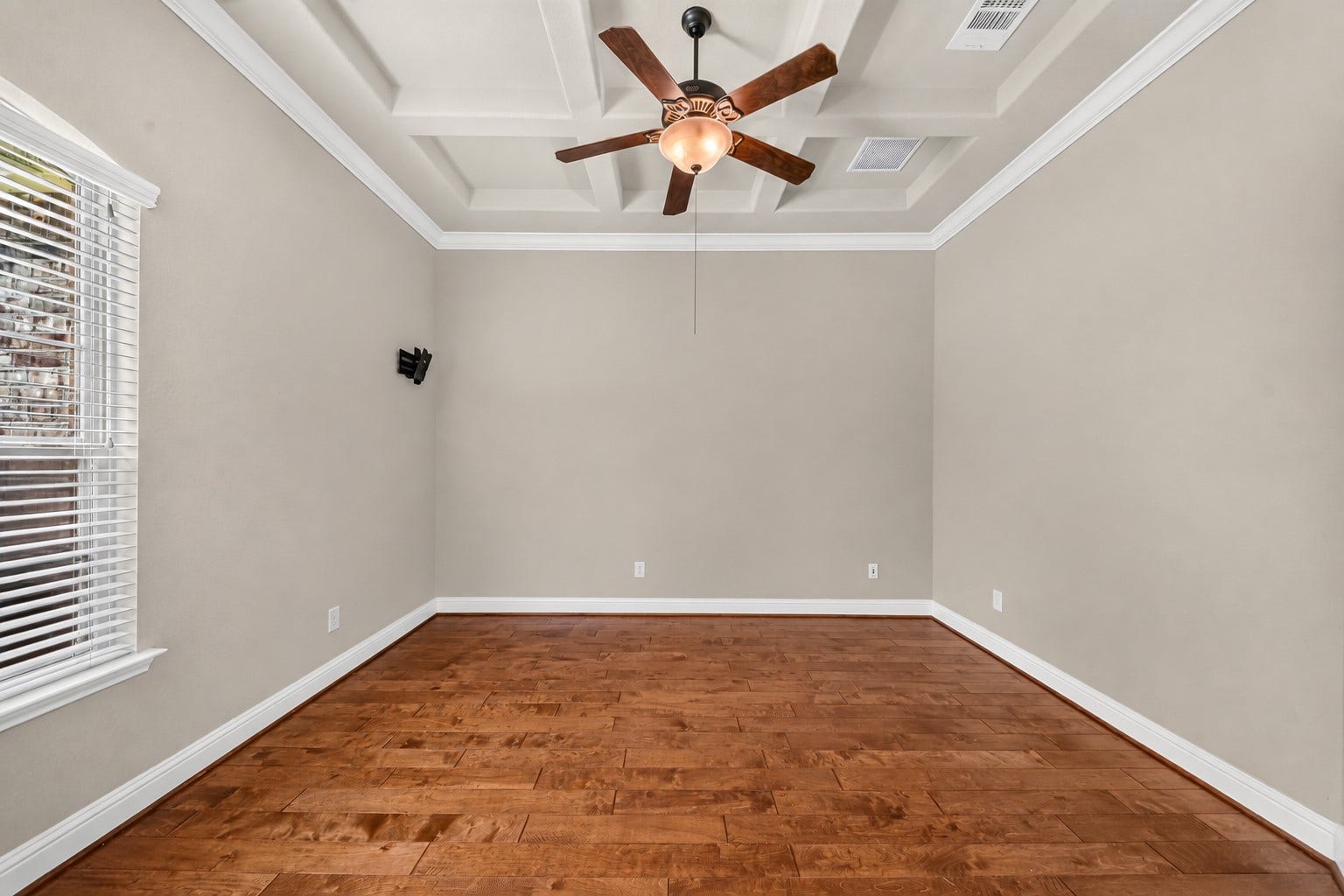 12218 Rampy Green Drive, Tomball, TX 77377 Spacious study featuring elegant wood flooring, a stylish tray ceiling, and natural light from large window.