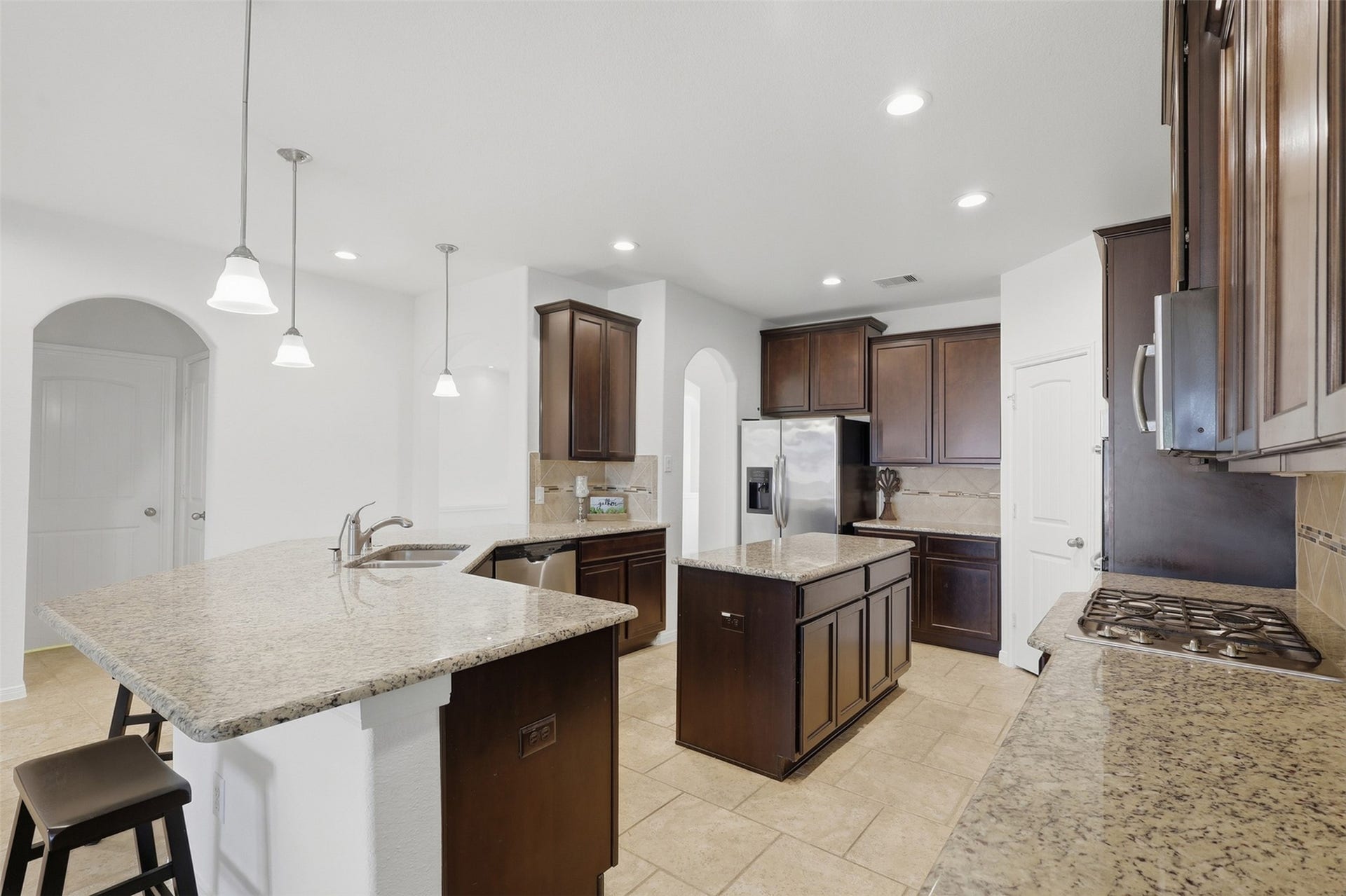 11723 Giovanni Lane, Richmond, TX 77406 The Kitchen Truly Becomes the Gathering Place! From this view, you can appreciate the generous counter space, large island, rich cabinetry, stainless steel appliances, and bright open layout. The kitchen flows naturally toward the dining and family areas, giving everyone plenty of room to cook, gather, and enjoy time together.