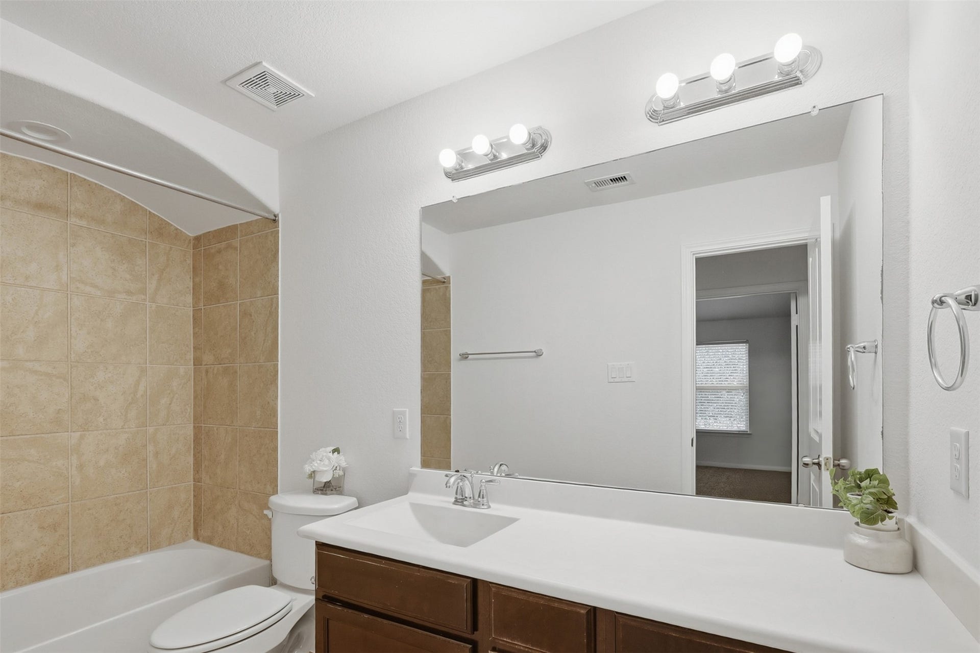 11723 Giovanni Lane, Richmond, TX 77406 Clean, Bright & Nicely Appointed! This secondary bath features a generous vanity with plenty of counter space, a large mirror, and attractive lighting. Warm cabinetry and neutral finishes give the room a fresh, timeless appearance that is both practical and inviting.