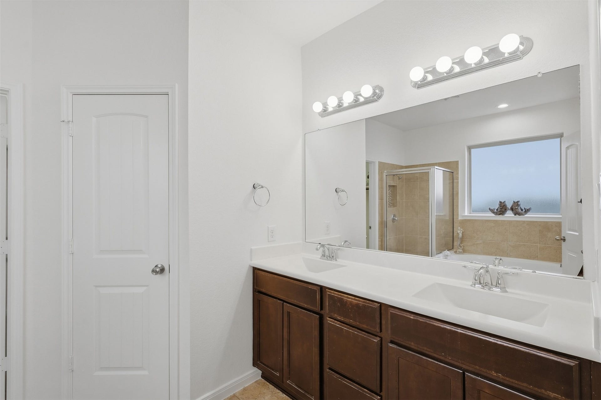 11723 Giovanni Lane, Richmond, TX 77406 Beautifully Finished Primary Bath! The spacious double vanity offers plenty of counter space and storage, complemented by elegant lighting and a large mirror. The warm cabinetry and bright finishes create a clean, comfortable space that is both practical and inviting.