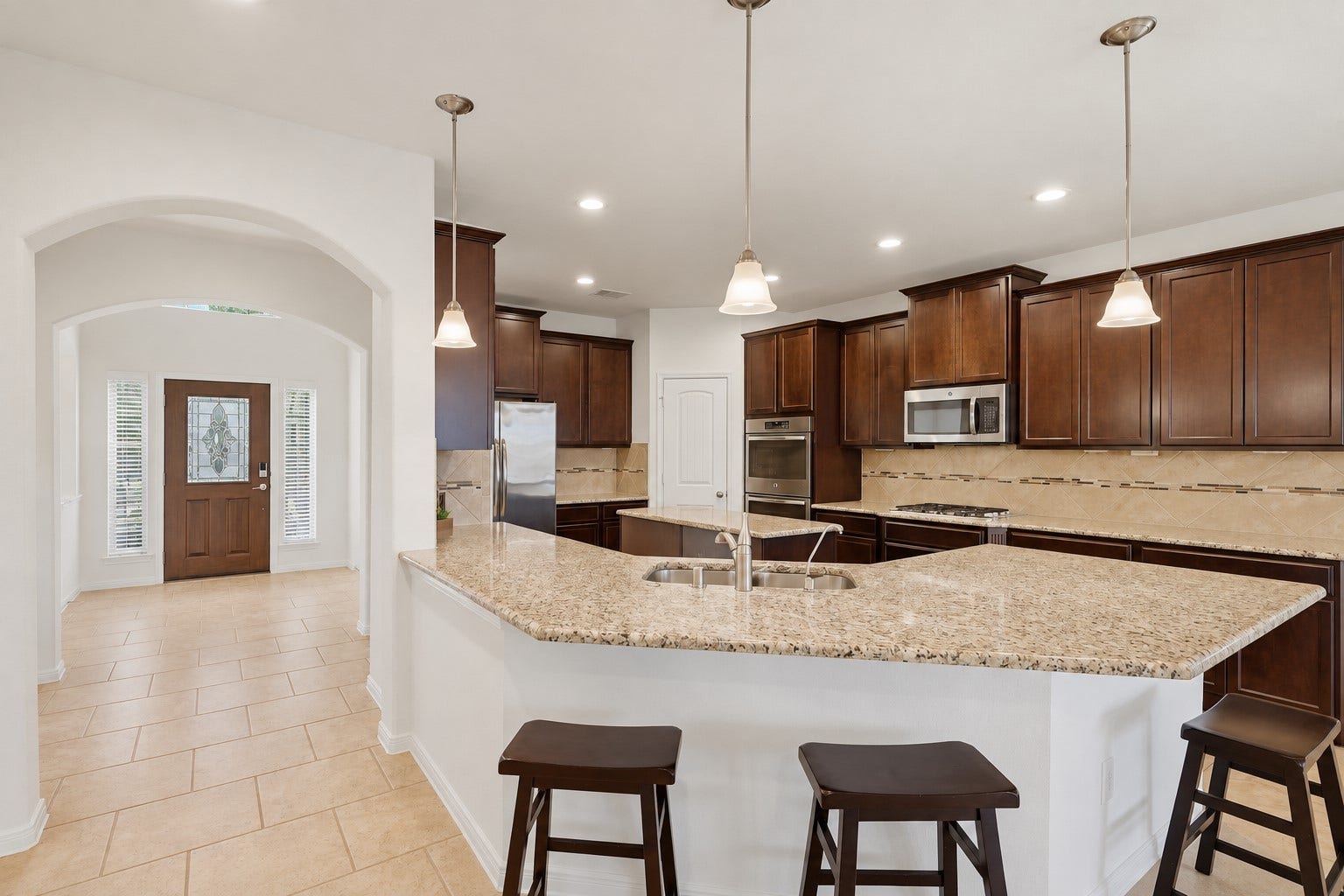 11723 Giovanni Lane, Richmond, TX 77406 Plenty of Room for Everyone in This Beautiful Kitchen! The generous breakfast bar and oversized granite counters provide wonderful space for casual meals, morning coffee, or visiting with family while dinner is being prepared. Rich custom cabinetry, pendant lighting, and the open layout make this kitchen both beautiful and wonderfully functional.