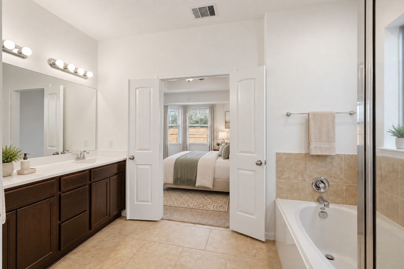 11723 Giovanni Lane, Richmond, TX 77406 A Lovely Spa-Inspired Primary Bath! The spacious primary bath features a beautiful double vanity, generous mirror, soaking tub, separate glass-enclosed shower, and warm tile flooring. The bright, clean design creates a relaxing atmosphere and provides plenty of room to start the morning or unwind at the end of the day. *Photo is virtually staged*