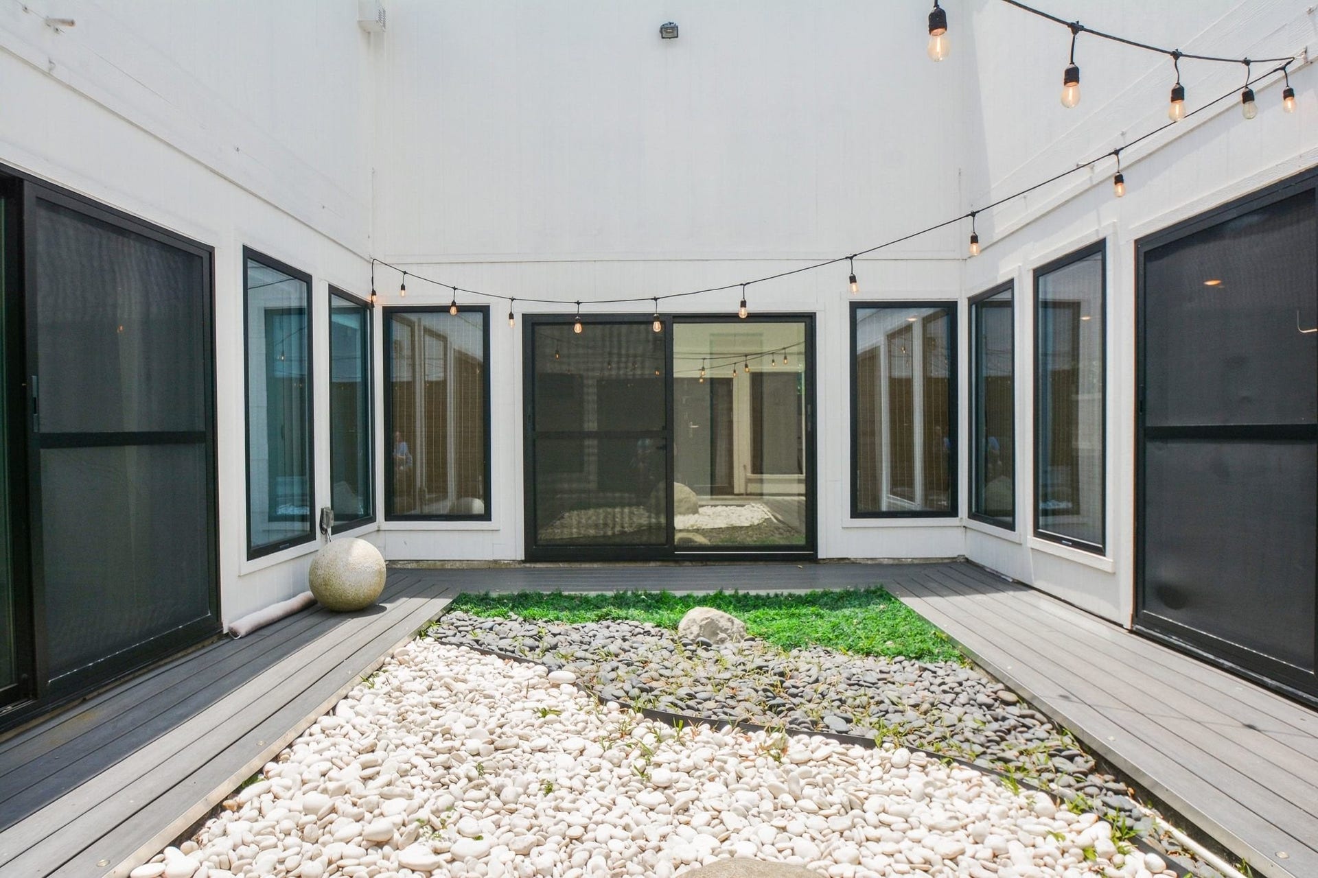 Private interior courtyard providing a peaceful outdoor retreat surrounded by large windows.