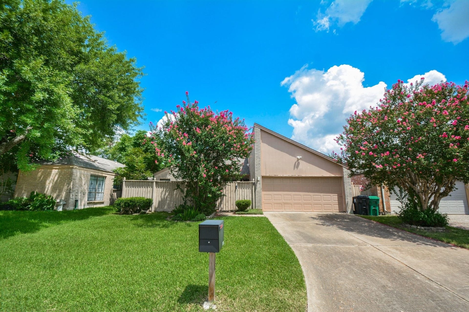 Beautifully maintained front exterior with lush landscaping and mature trees.