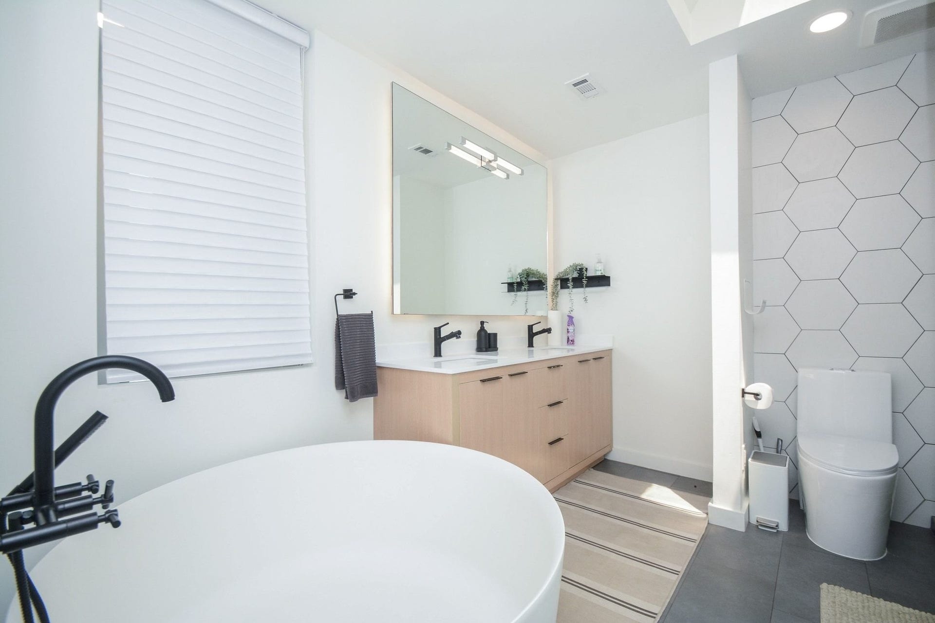 Elegant primary bathroom featuring modern vanity, freestanding soaking tub, and updated finishes.