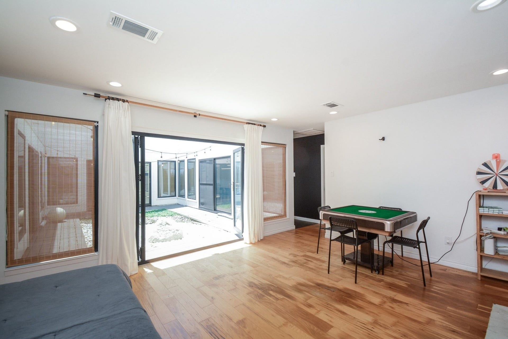 Bright open living area with contemporary flooring, updated finishes, and courtyard views.