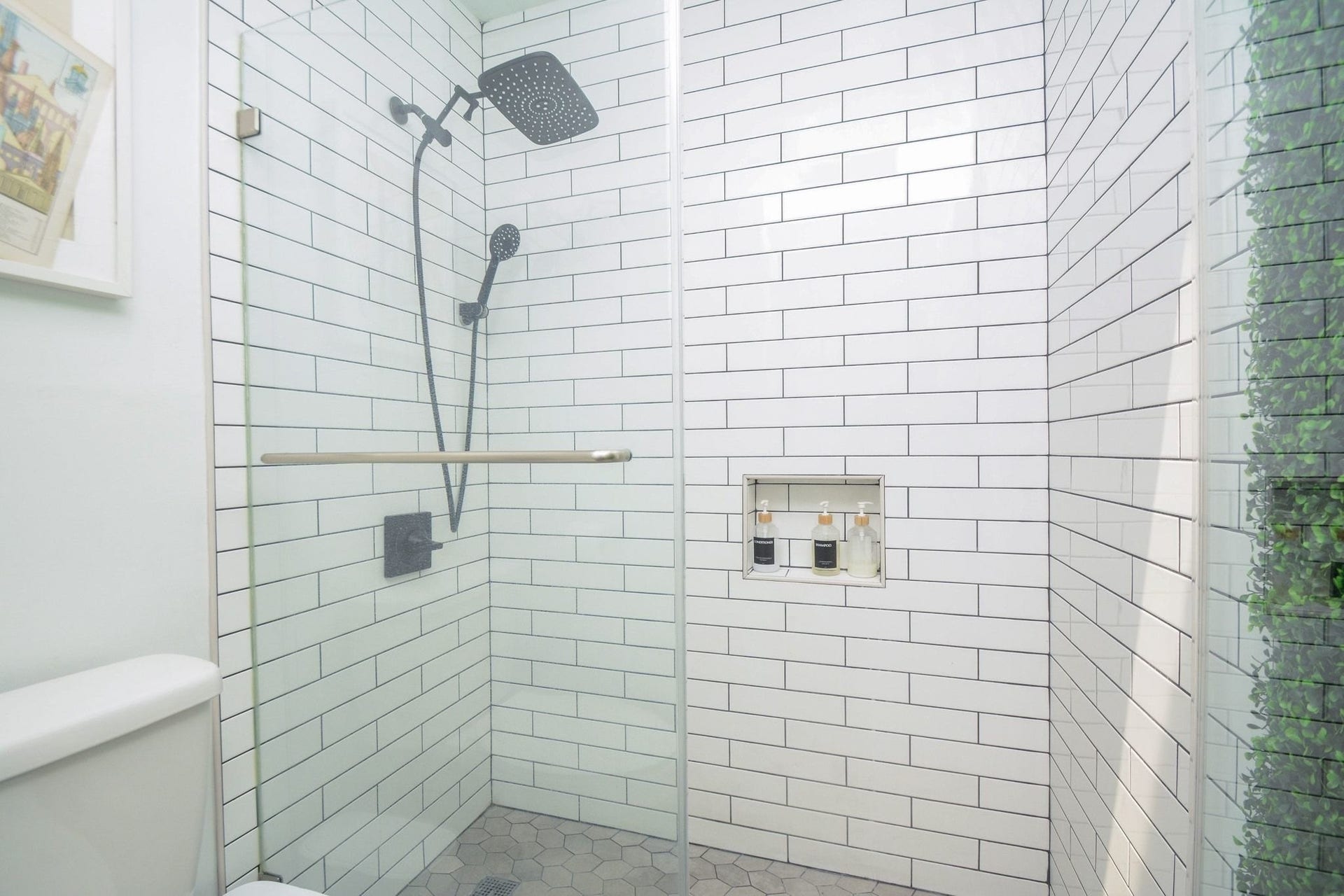 Fully updated walk-in shower featuring designer tile, modern fixtures, and built-in shelving