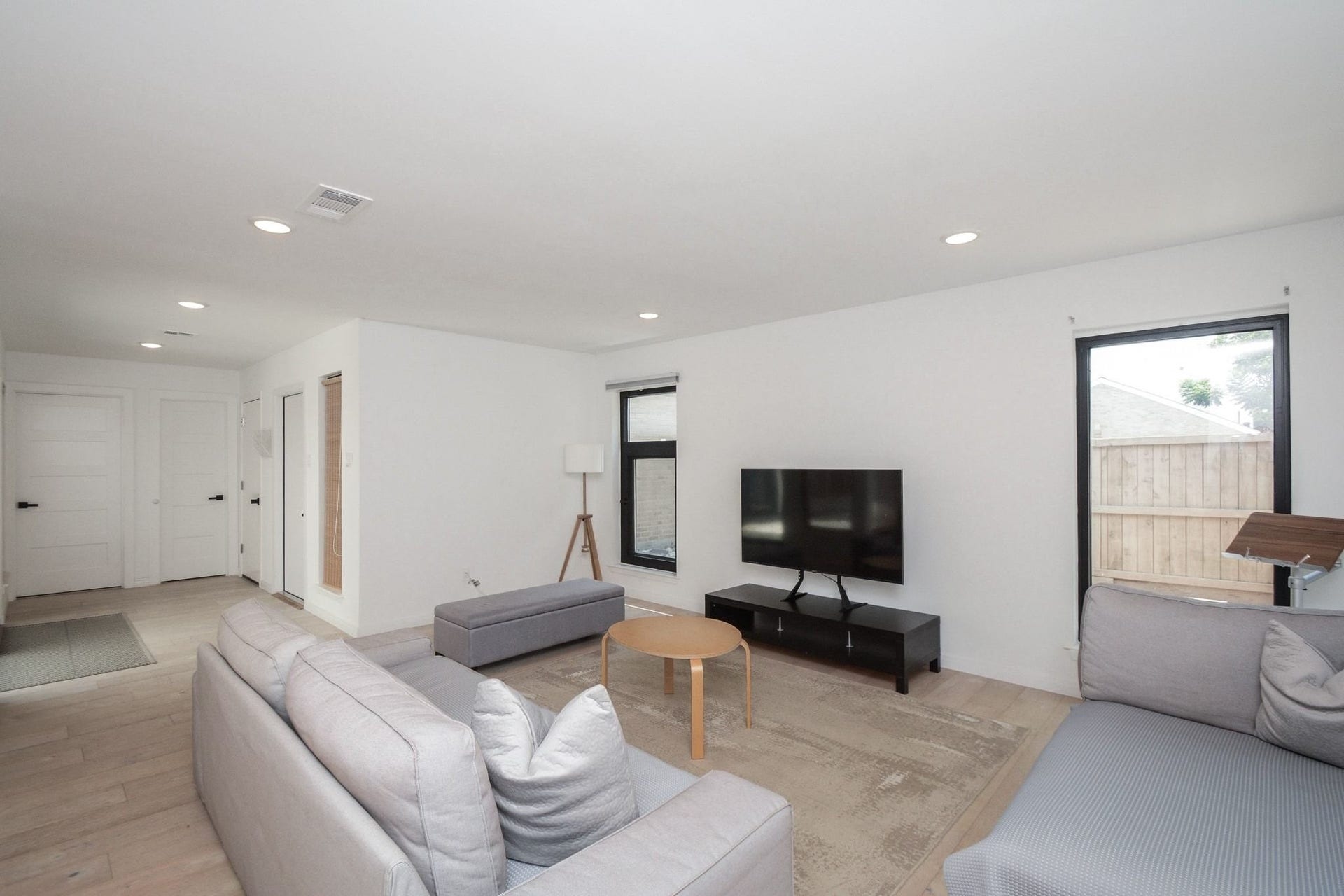 Spacious living room with modern fireplace, updated flooring, and large windows overlooking the courtyard.
