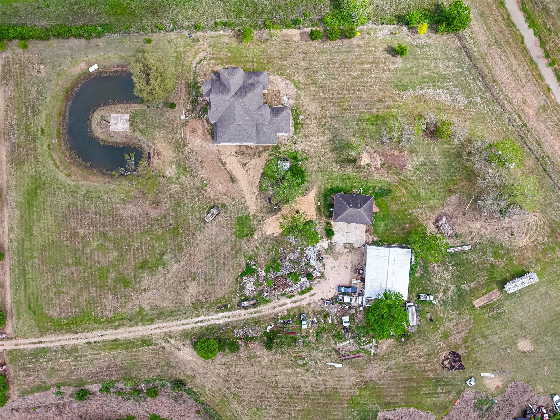 8023 Pool Hill Road, Fulshear, TX 77441 Aerial view of the property showcasing multiple structures, pond, and expansive grounds.