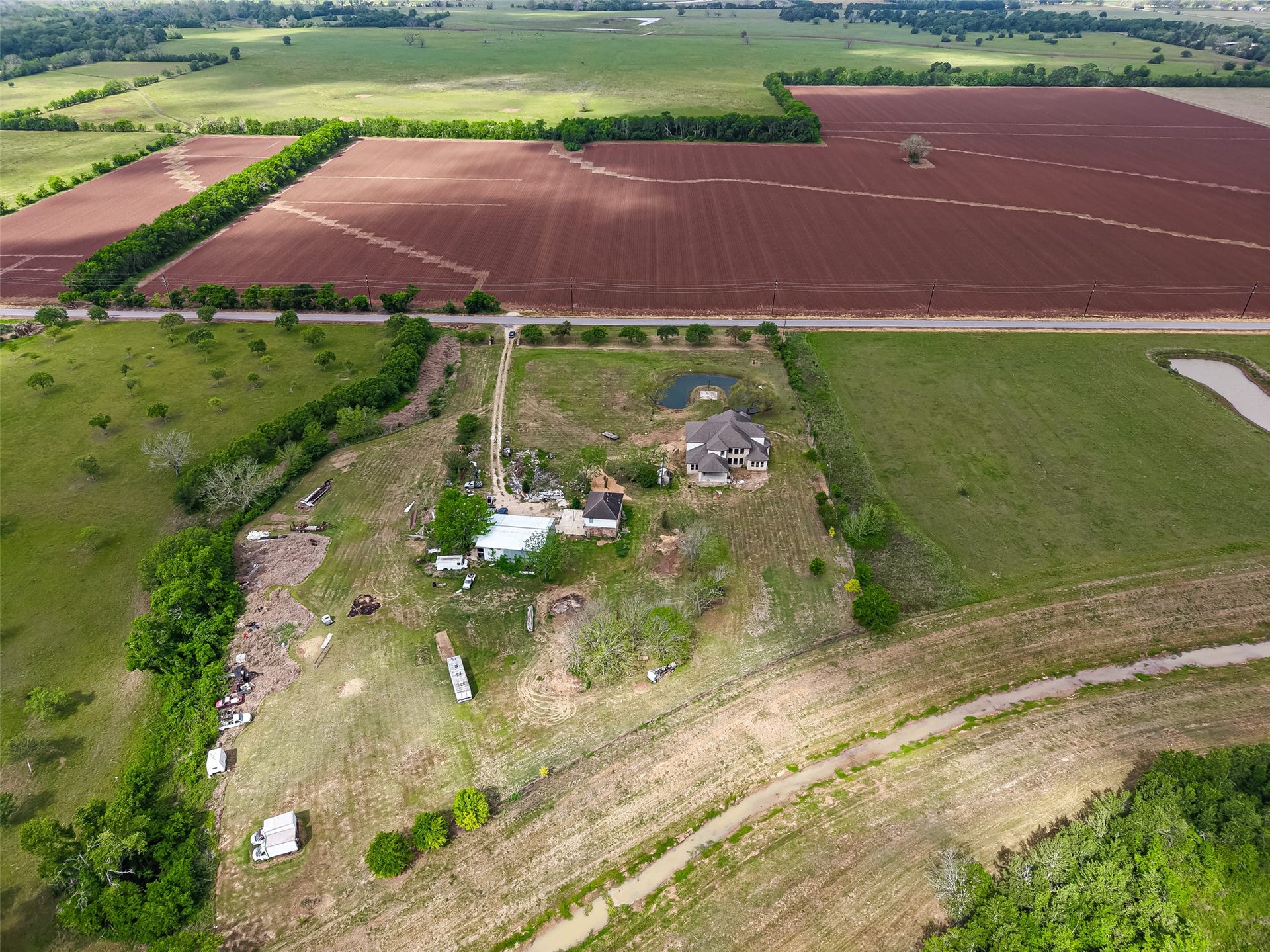 8023 Pool Hill Road, Fulshear, TX 77441 Aerial perspective of the property with wide-open land and scenic rural surroundings.
