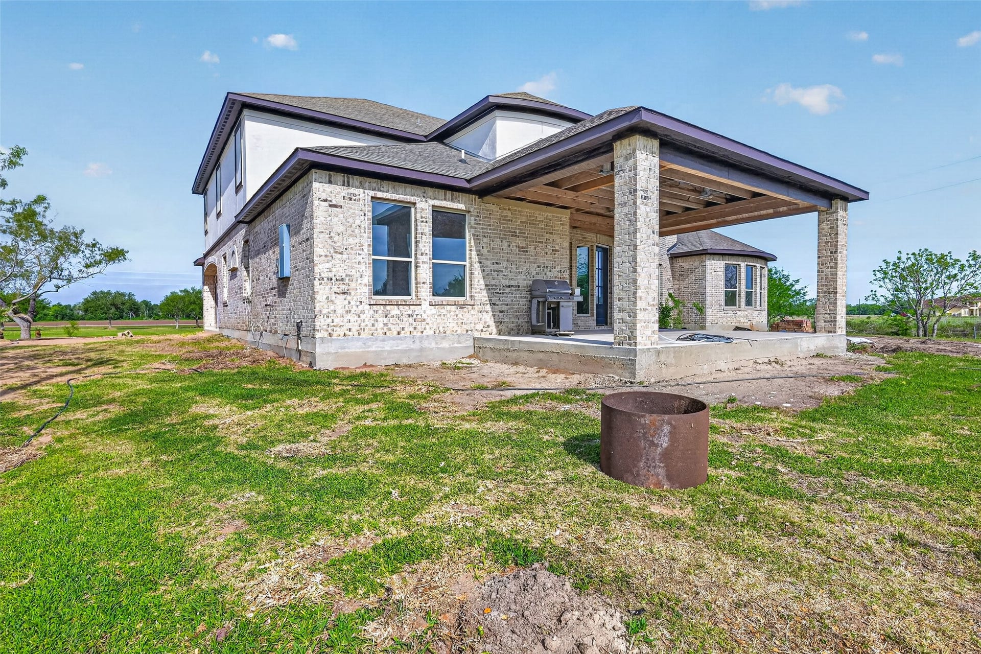8023 Pool Hill Road, Fulshear, TX 77441 Rear exterior of Property 1 unfinished residence with covered patio, open backyard, and view of the existing lawn.