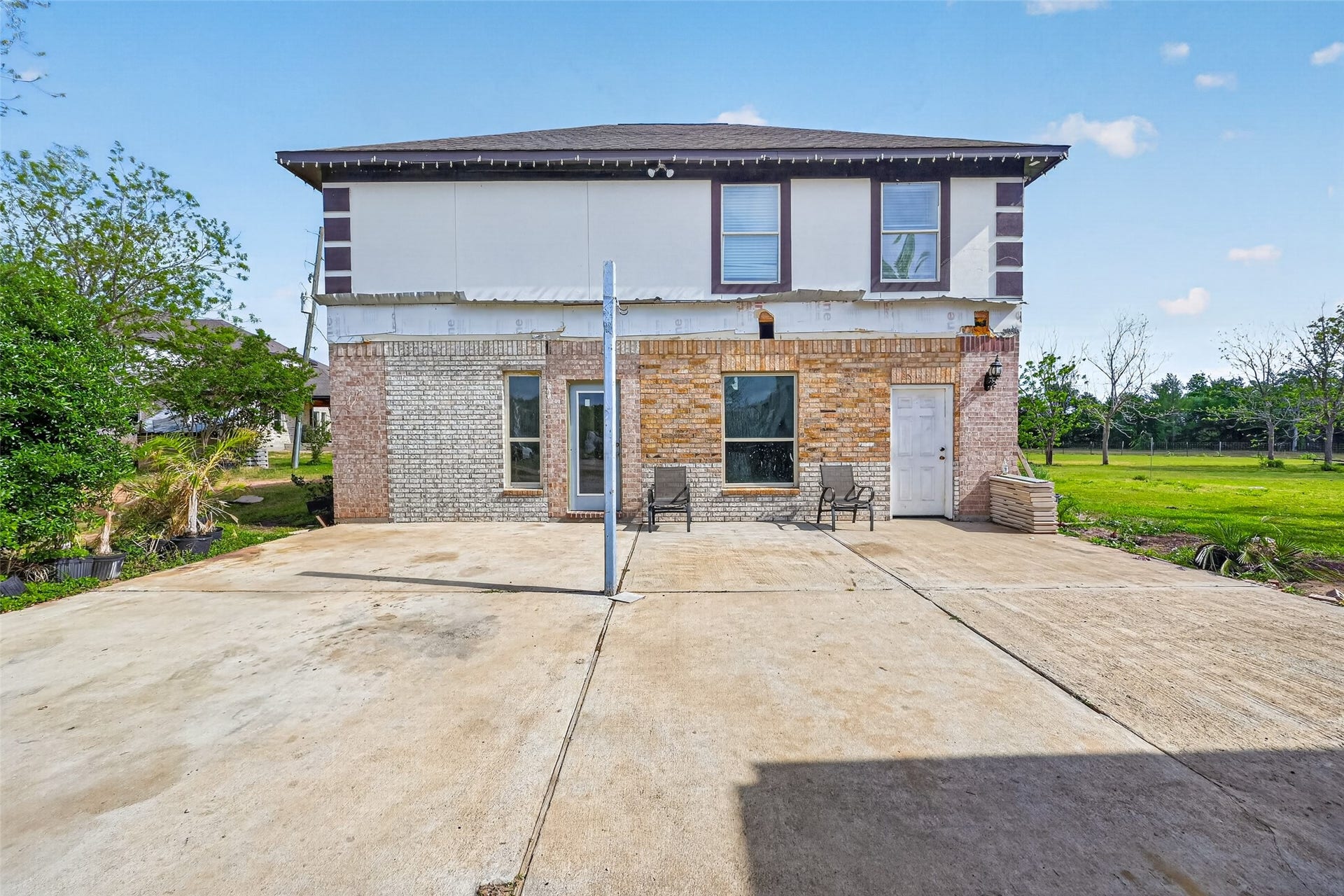 8023 Pool Hill Road, Fulshear, TX 77441 Front exterior of Property 2 semi-finished residence with main level under construction, completed second-level living area, and large concrete pad.