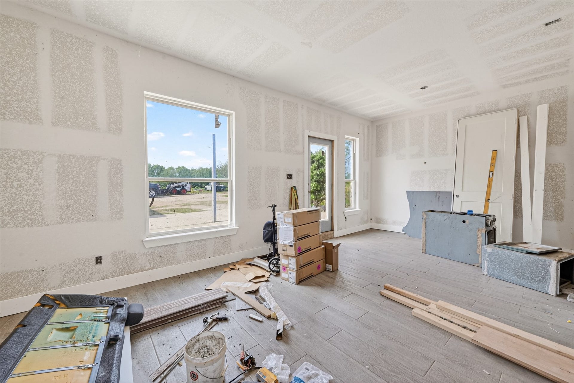 8023 Pool Hill Road, Fulshear, TX 77441 Main-level unfinished interior with open-concept layout, natural light, and construction underway.