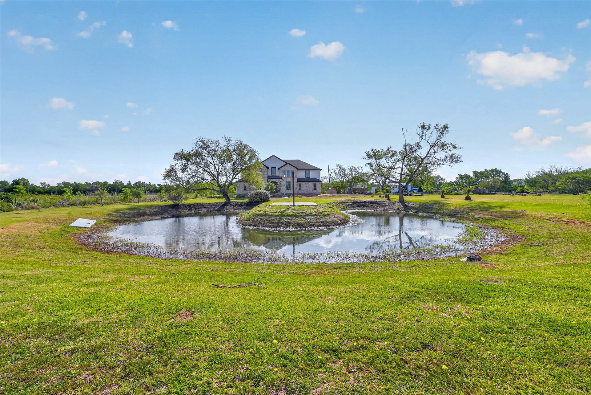 8023 Pool Hill Road, Fulshear, TX 77441 Pond view with open grassy surroundings and peaceful rural setting.