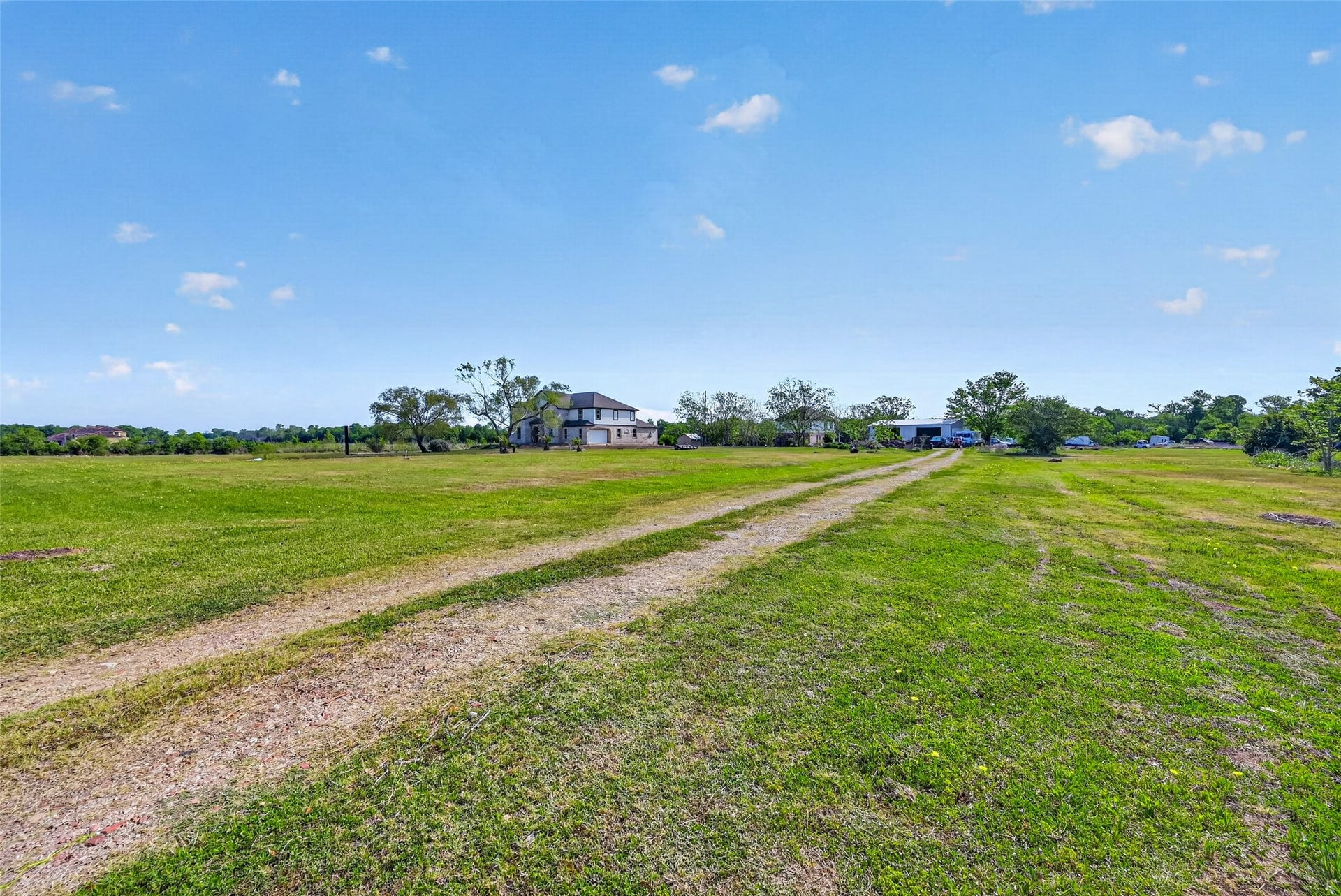 8023 Pool Hill Road, Fulshear, TX 77441 Drive approach through the property showcasing expansive open land and rural surroundings.