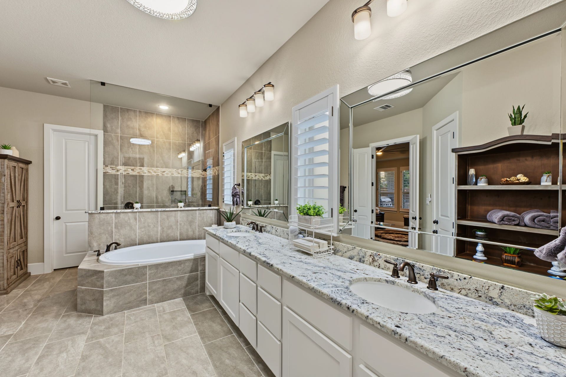 Spacious primary bathroom with dual sinks, generous counter space, and an elegant soaking tub, perfect for unwinding.