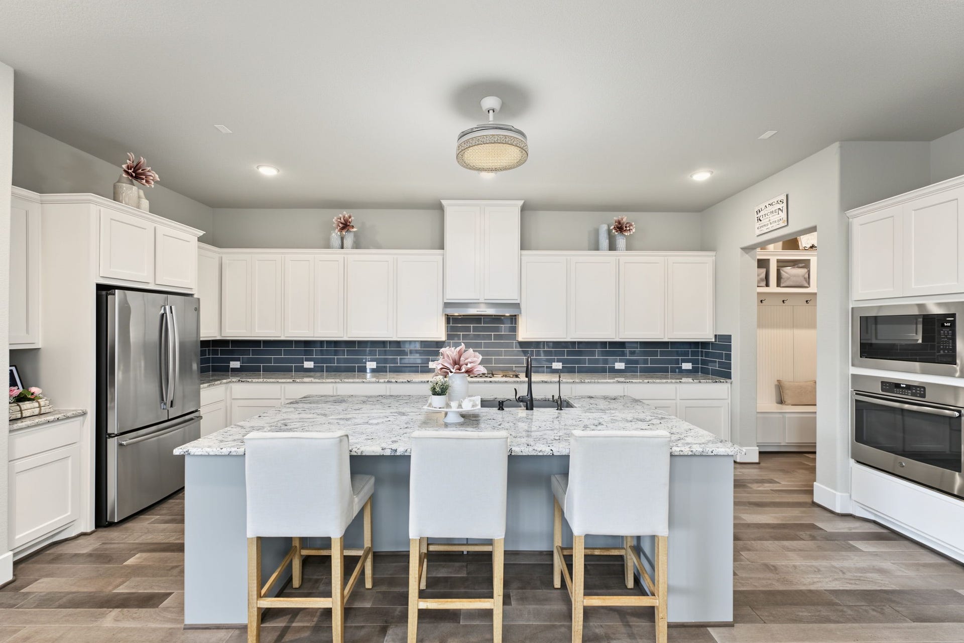 Gorgeous Gourmet Kitchen! Featuring an oversized island, beautiful granite countertops, white cabinetry, and stylish contrasting backsplash.