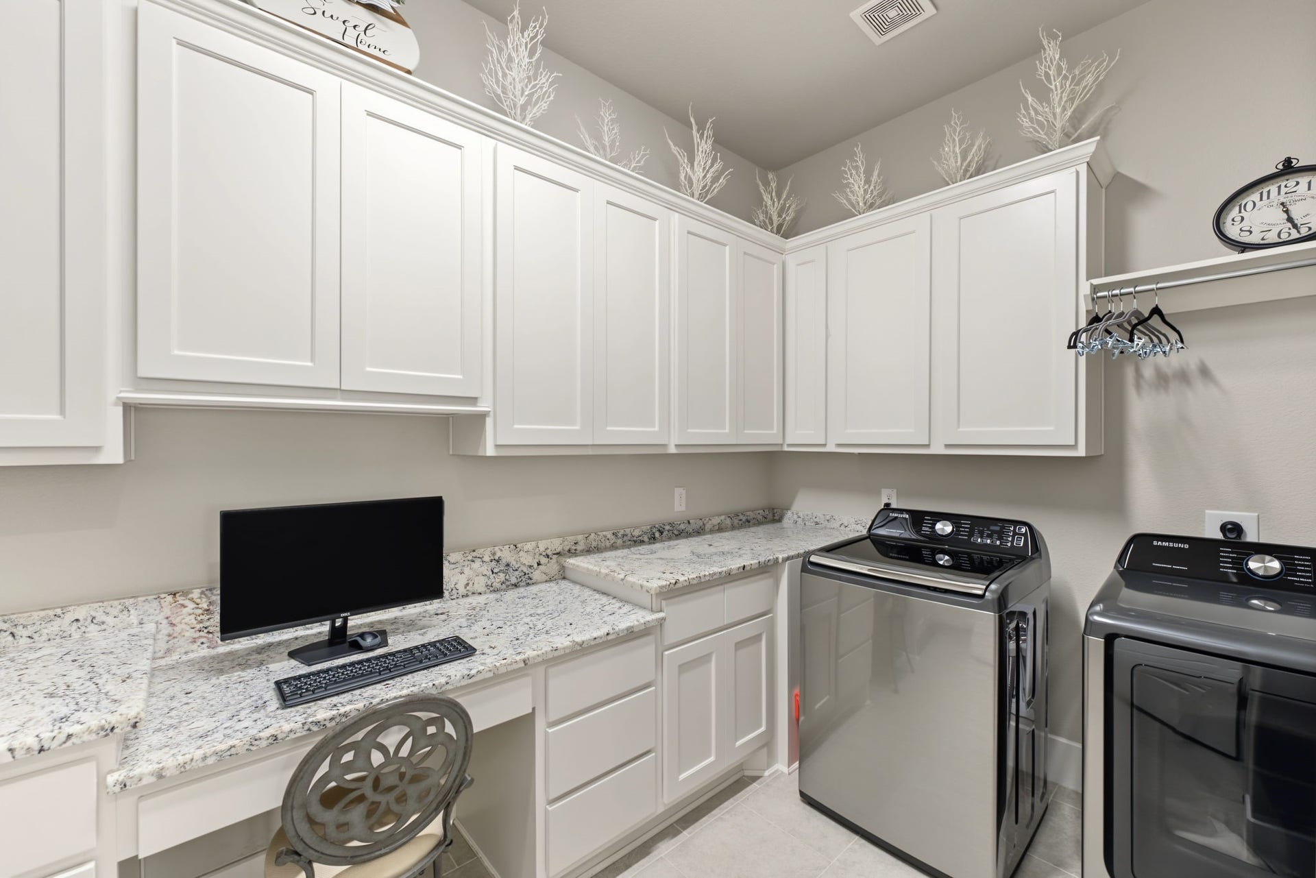 Exceptional Laundry Room! Spacious laundry area featuring abundant custom cabinetry, granite countertops, and a convenient built-in workspace.