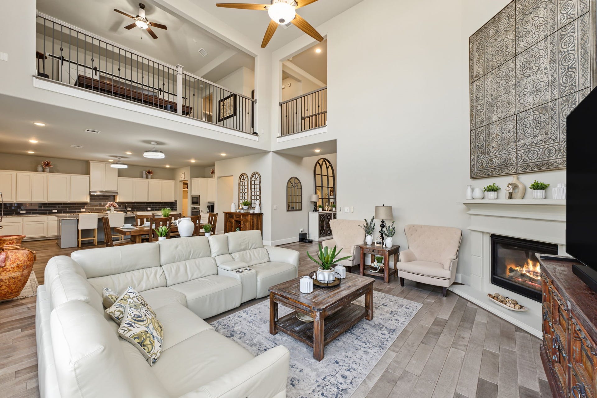 Spacious living area featuring a cozy fireplace, soaring ceilings, and an open layout perfect for relaxing or entertaining.