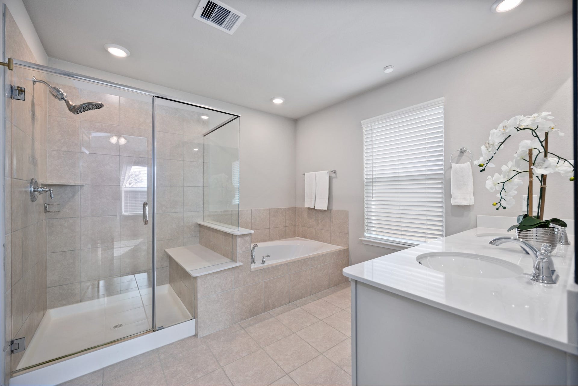 11403 Brookside Arbor Lane, Richmond, TX 77406 Relax and rejuvenate in the lavish en suite bath featuring neutral finishes, a large soaking tub, and separate shower with a built-in bench and shelf storage.