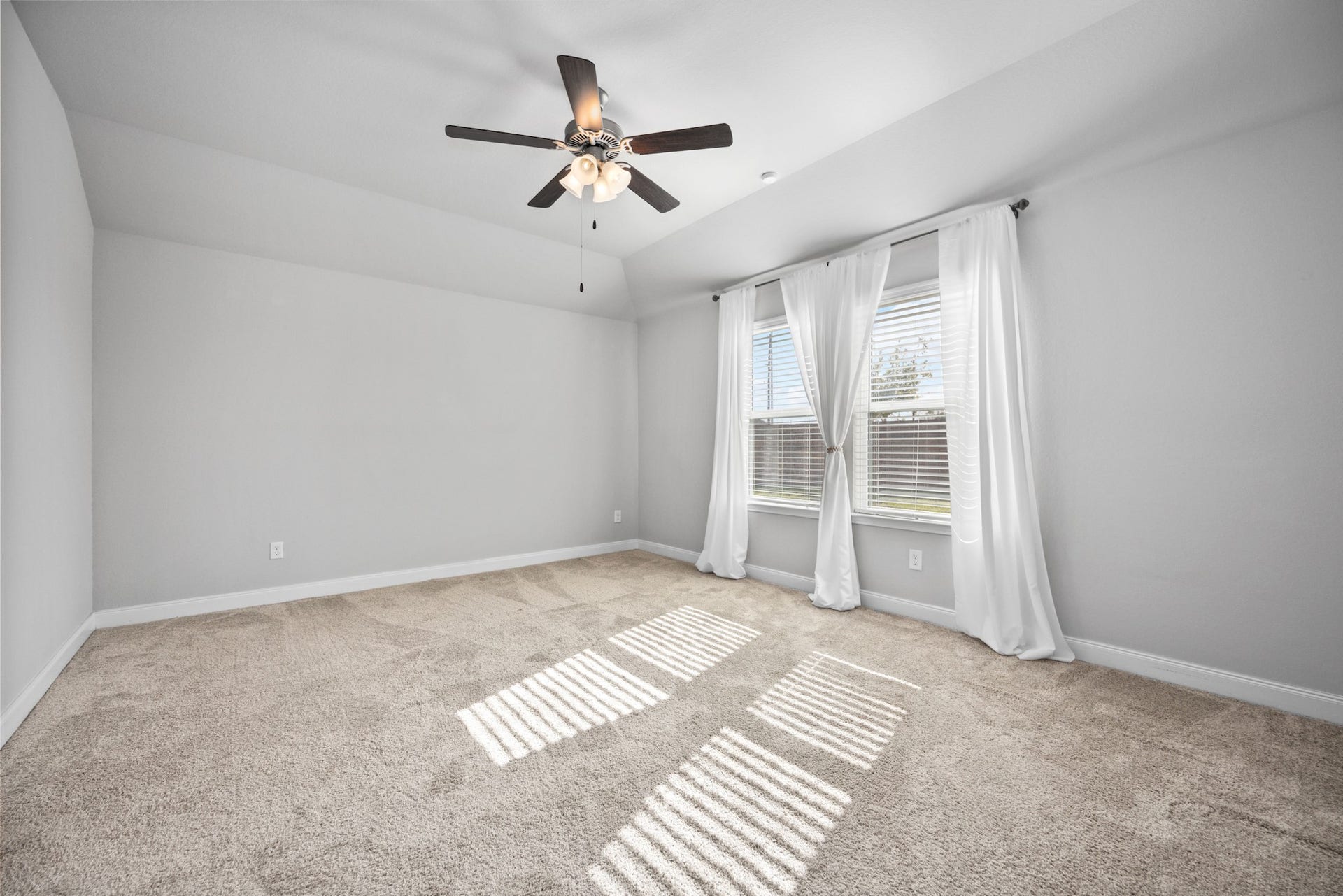 11403 Brookside Arbor Lane, Richmond, TX 77406 Relax in the Primary Bedroom, adorned with plush neutral carpeting, windows overlooking the backyard, and a comforting ceiling fan.