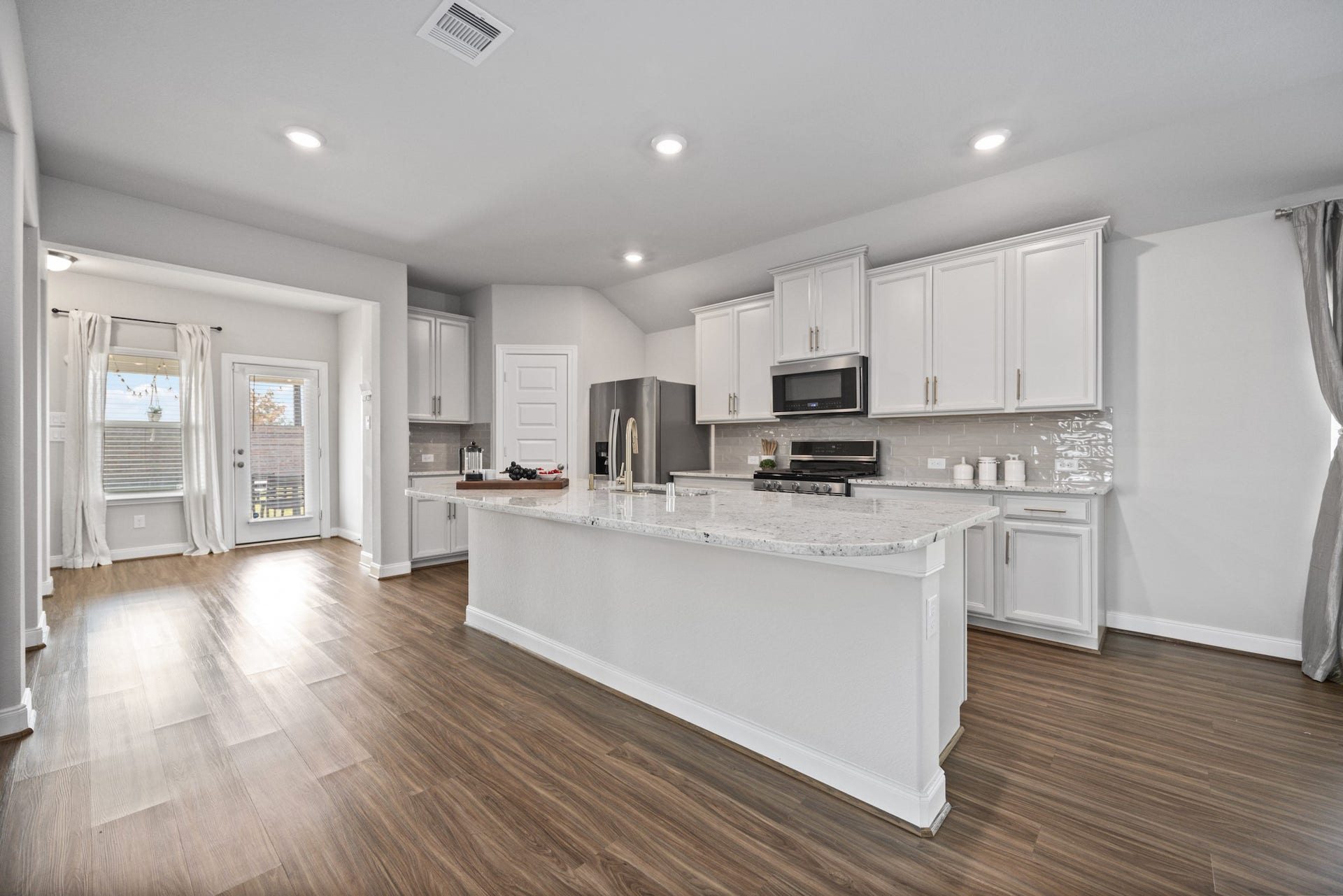 11403 Brookside Arbor Lane, Richmond, TX 77406 In the heart of the home is a gourmet kitchen featuring attractive light-colored granite countertops, chic grey subway tile backsplash, tasteful shaker-style cabinets, and recessed LED lights.